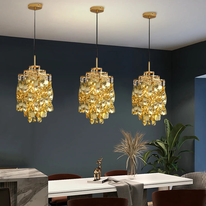 Trio of Arezzo crystal pendant lights hanging above a modern dining table.