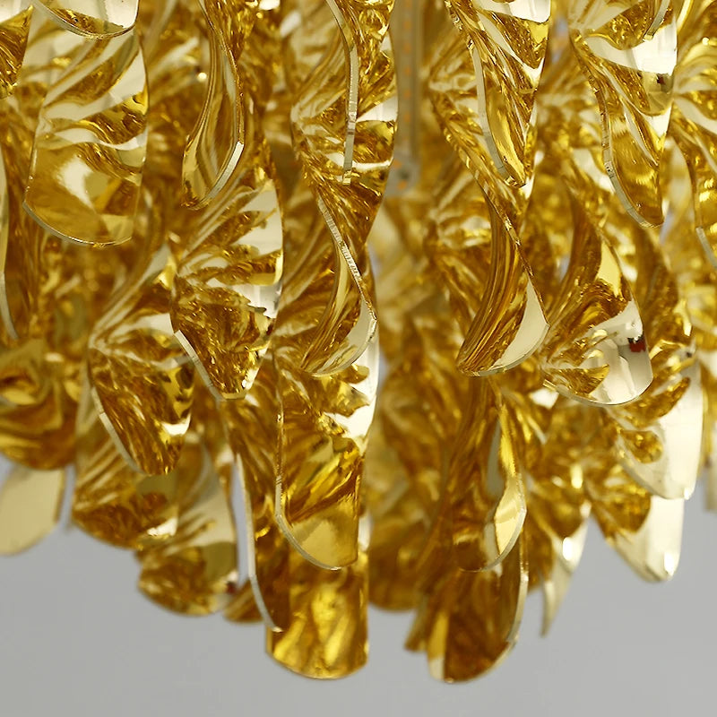Close-up of layered diamond cut crystals creating a shimmering gold pendant design.