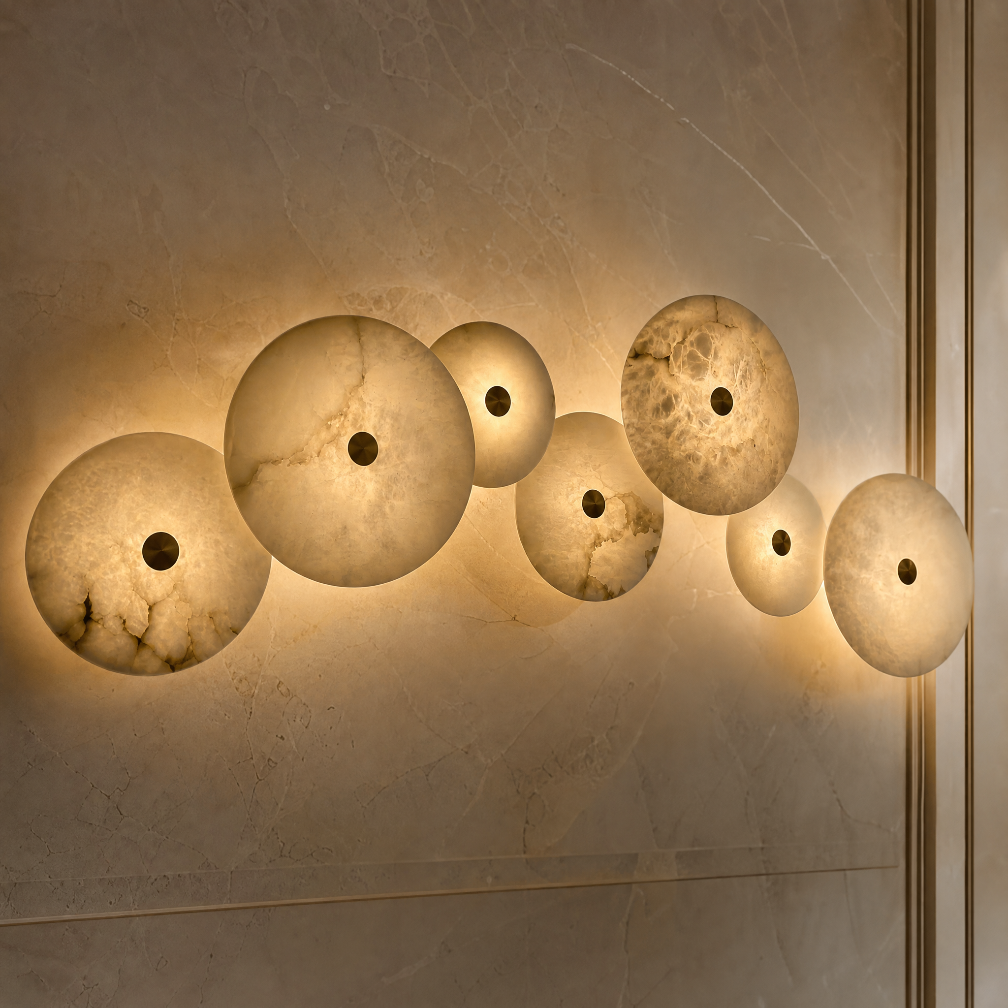Detailed closeup of the VORELLI Aria wall light showcasing the unique natural veining of the circular marble disc and the polished brass central accent.