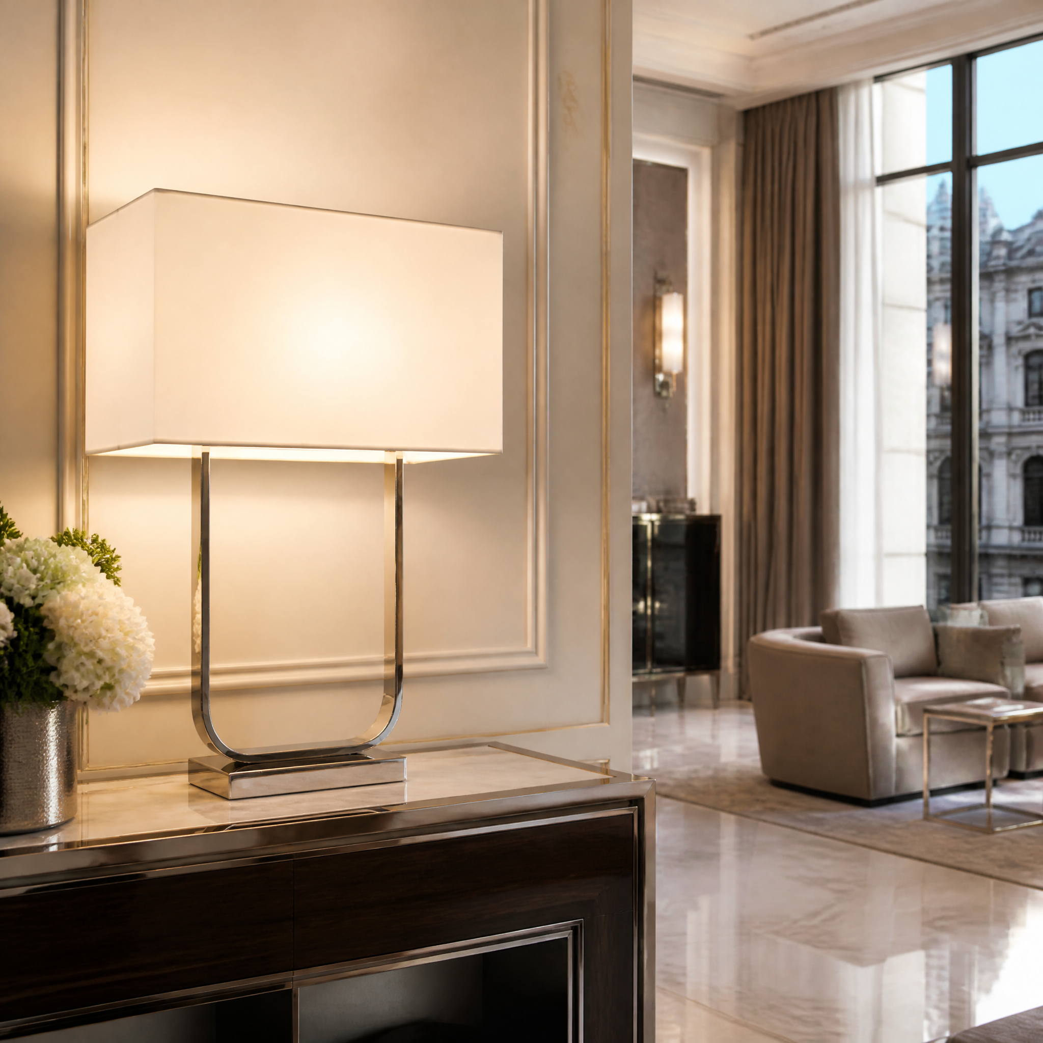 A pair of Arvelle polished nickel table lamps with crisp white shades styling a luxury hotel suite bedside arrangement.
