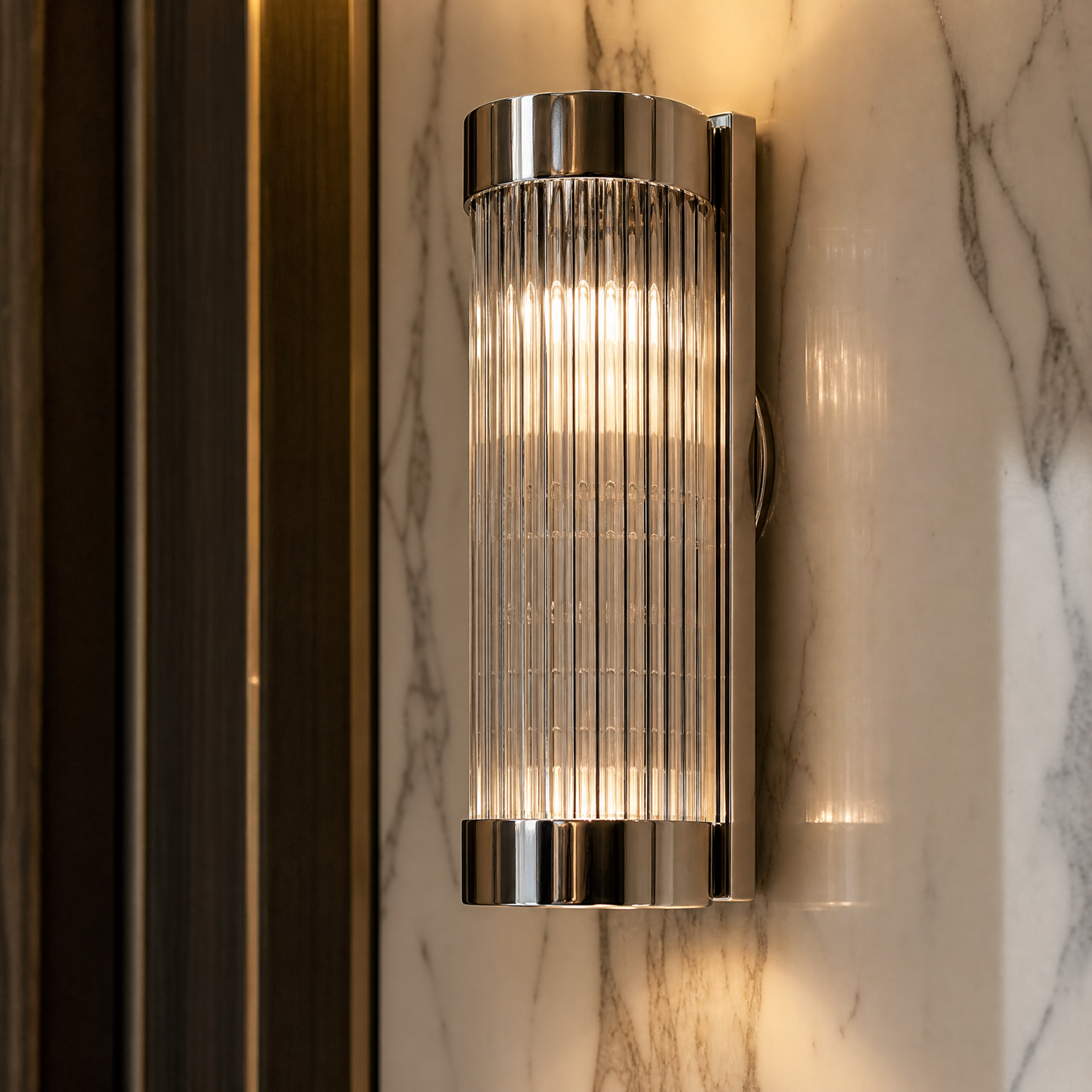 Close-up detail of the Aurelio wall light highlighting the vertical ribbed glass and polished nickel finish.