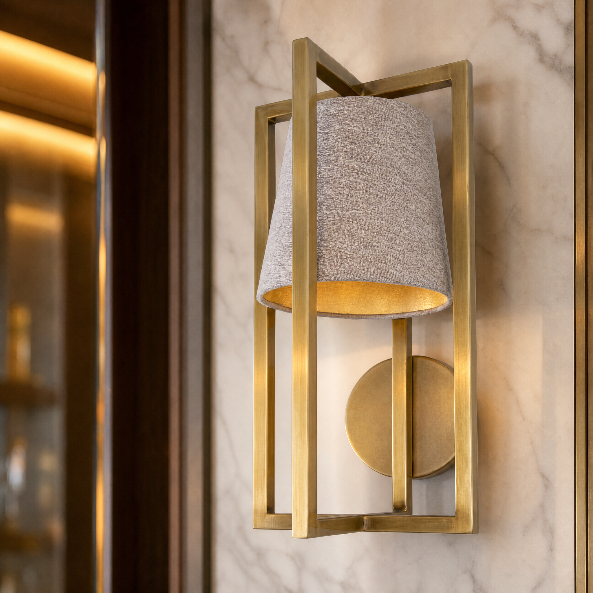 Detailed view of the Aurex Gold Wall Light showing the refined off-white fabric shade and architectural gold metal layering.