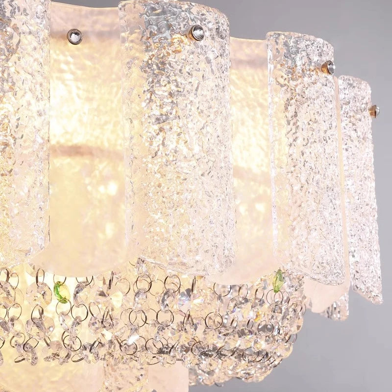Close-up view of Avino chandelier’s frosted glass panels and crystal detailing.