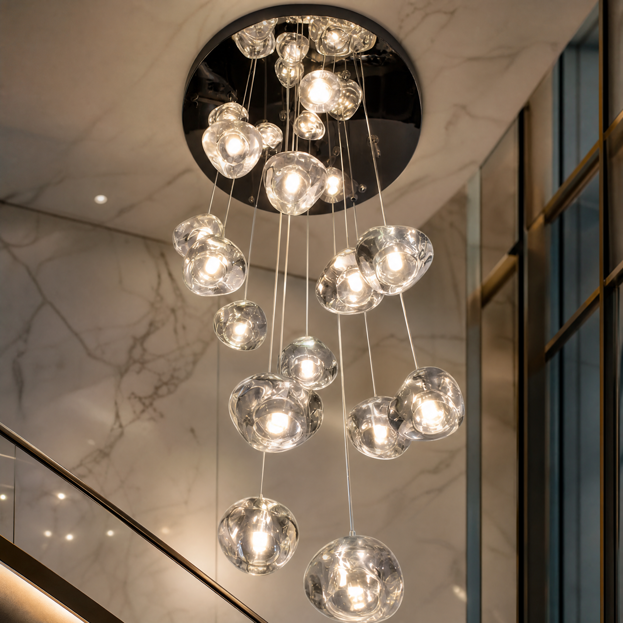 Detailed closeup of the hand-crafted glass pendants on the VORELLI Biella modern staircase chandelier, highlighting the artistic textures.