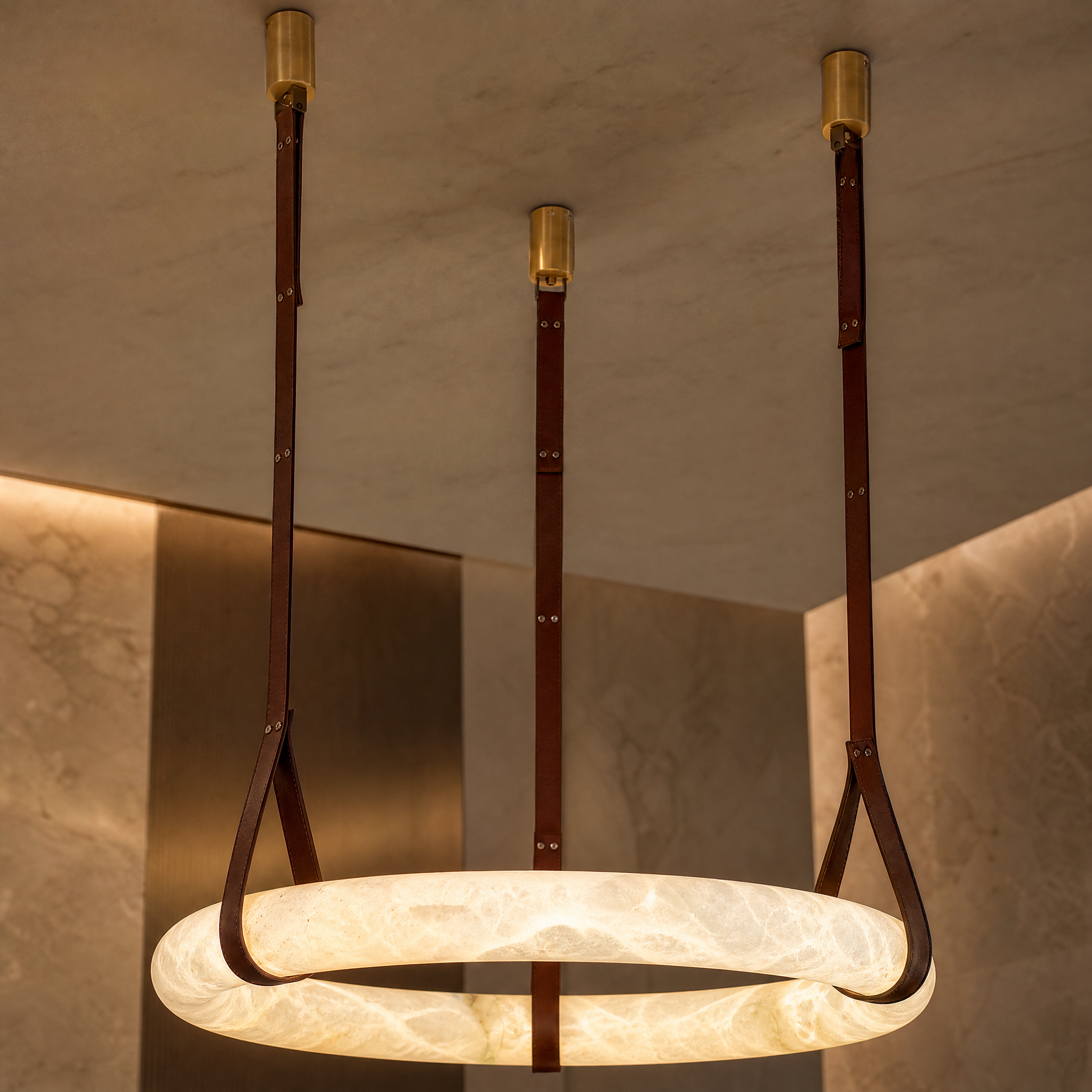 Macro detail shot showing the unique veining of Botticino marble paired with premium stitched leather trim on the Vorelli ceiling light.