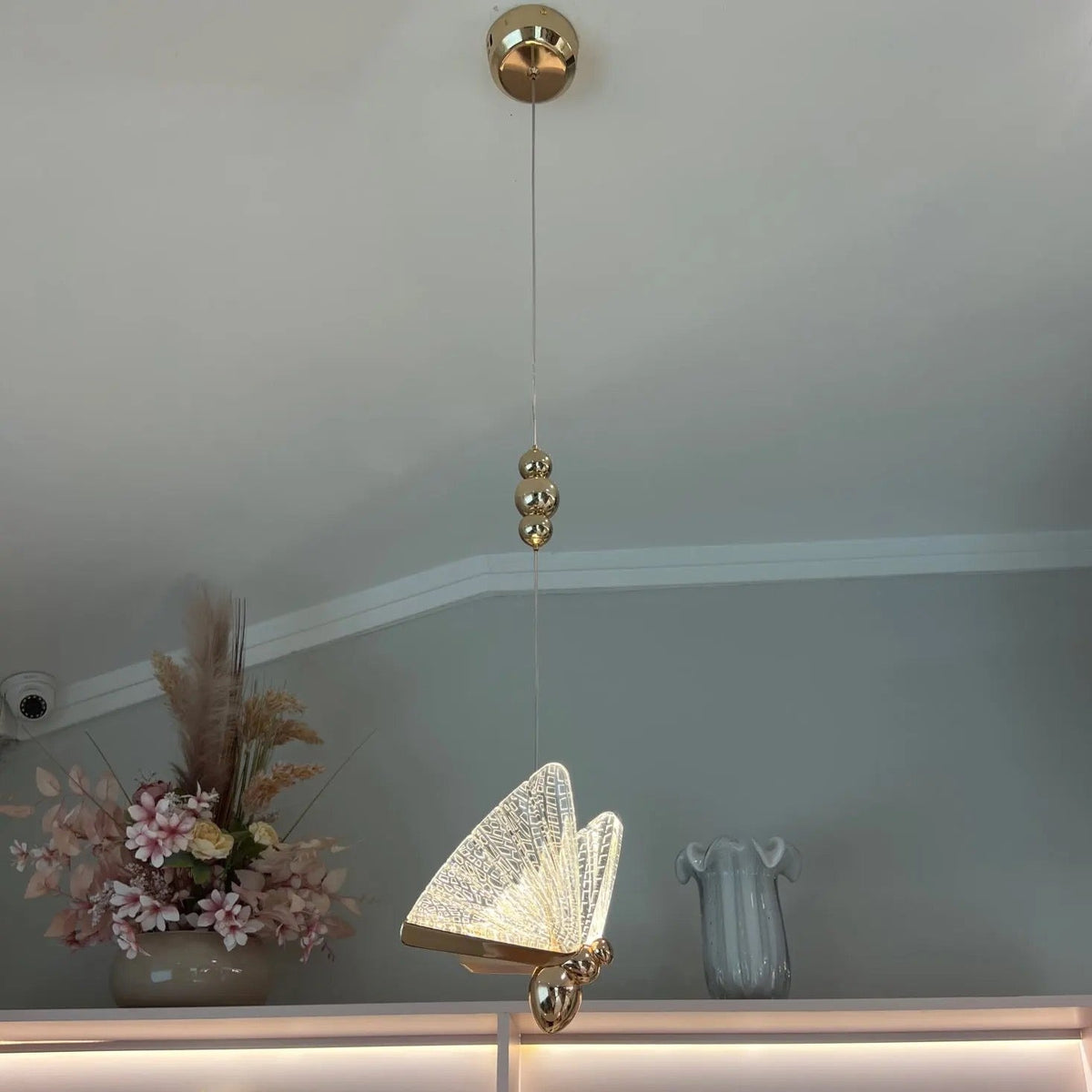 Butterfly Pendant Light against a deep blue backdrop, featuring luminous butterfly-shaped glass elements for a magical ambience.
