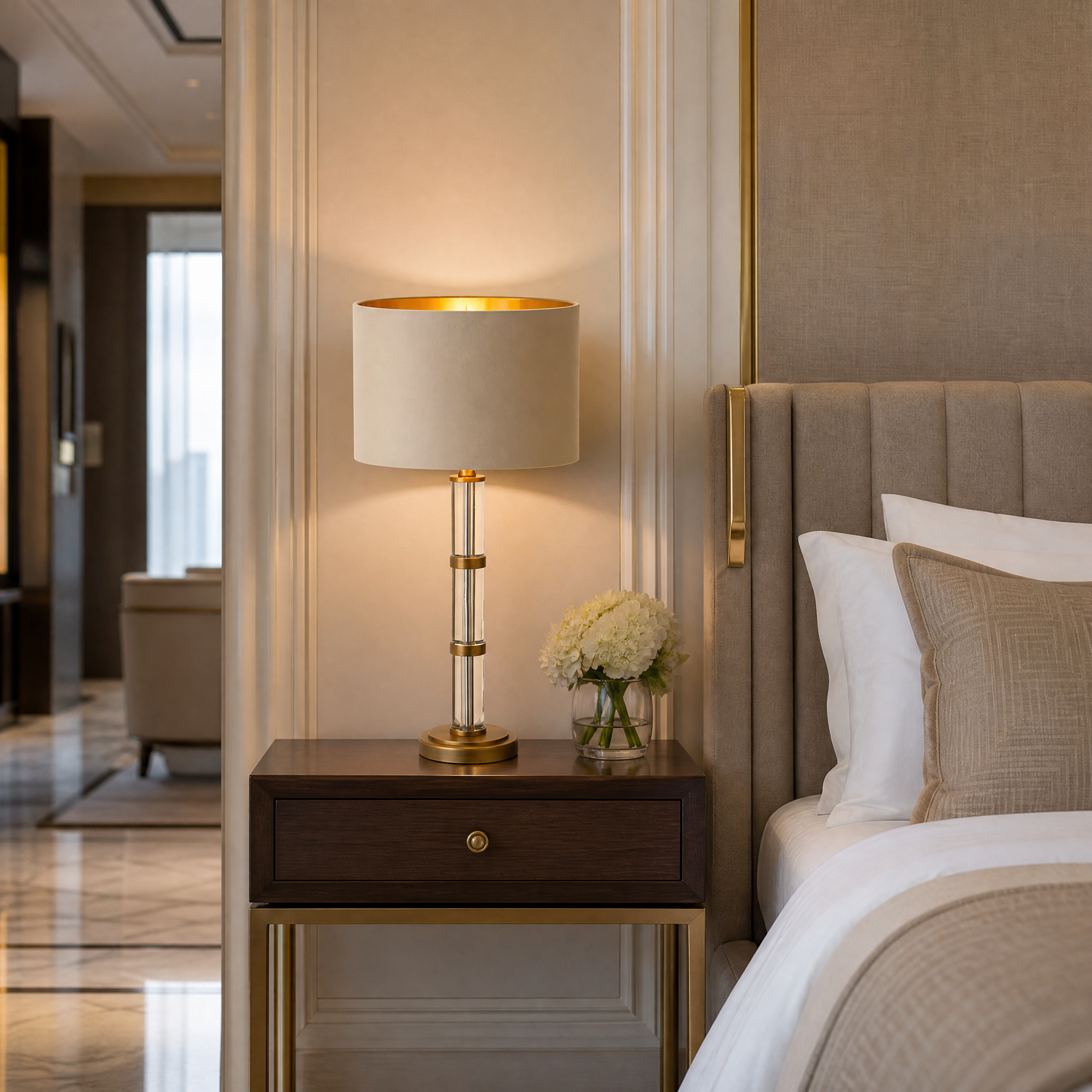 A pair of sophisticated Caldrin crystal table lamps providing elegant, ambient lighting on nightstands in a luxury hotel suite.