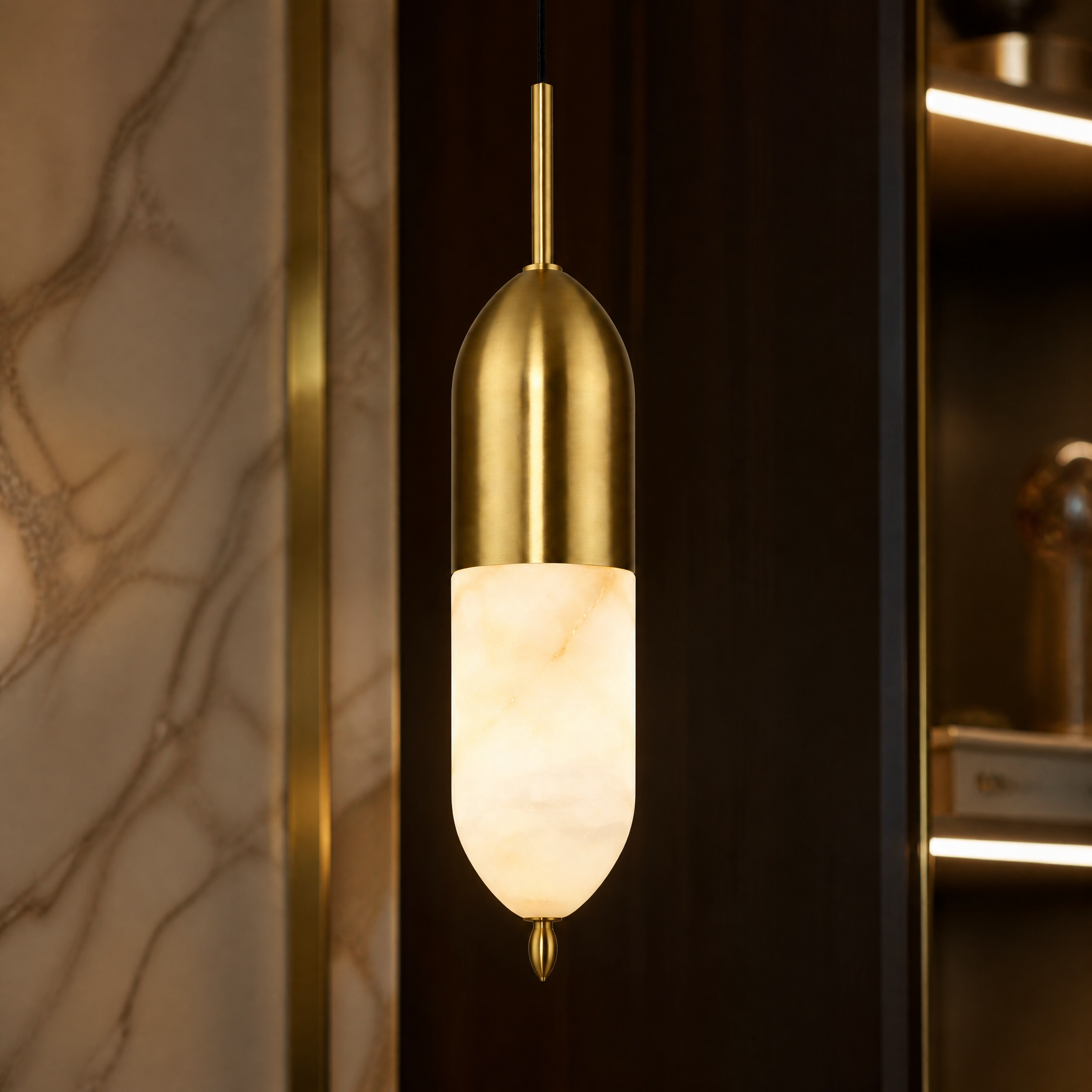 A detailed closeup shot of the VORELLI Castano pendant light highlighting the rich texture of the solid marble and the polished brass finial.
