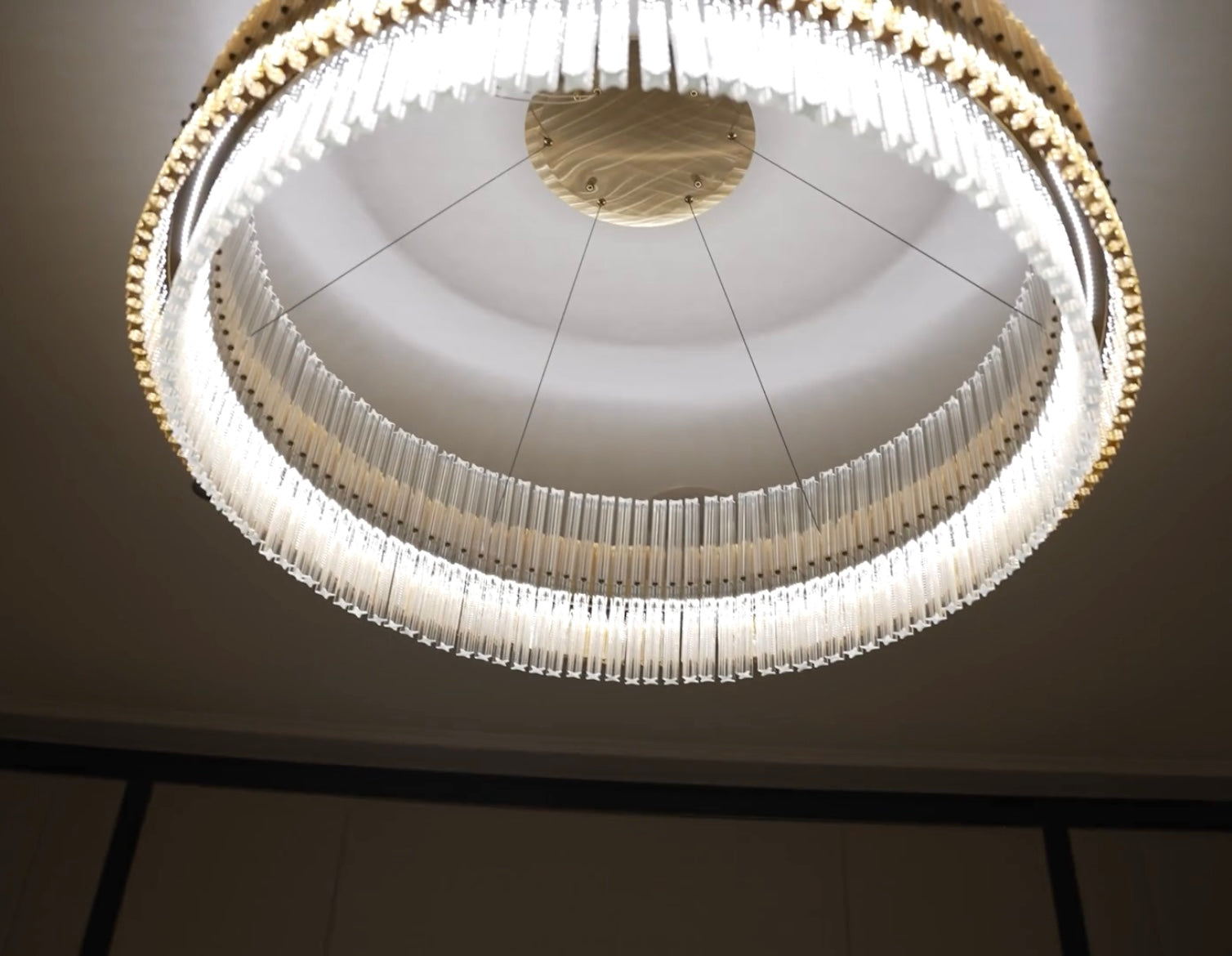 condotti circular chandelier glowing in modern interior with layered crystal arrangement