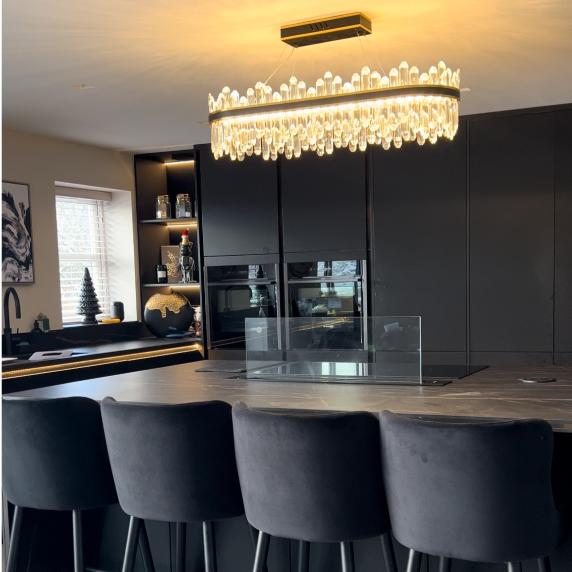 Detailed shot of the brushed titanium gold trim and matte black accents on the contemporary Sagres Rectangular Chandelier.