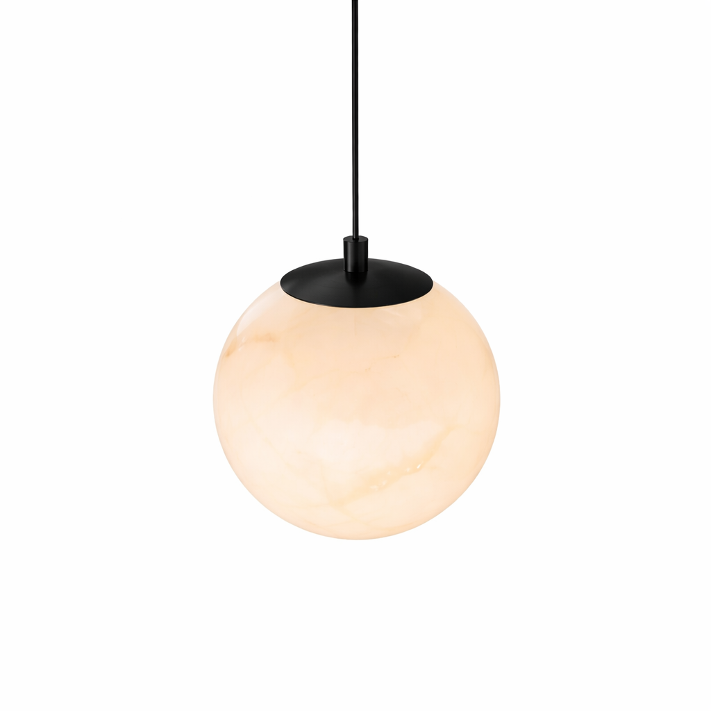 Duo of Jupiter alabaster pendants providing warm, ambient task lighting above a minimalist kitchen island.