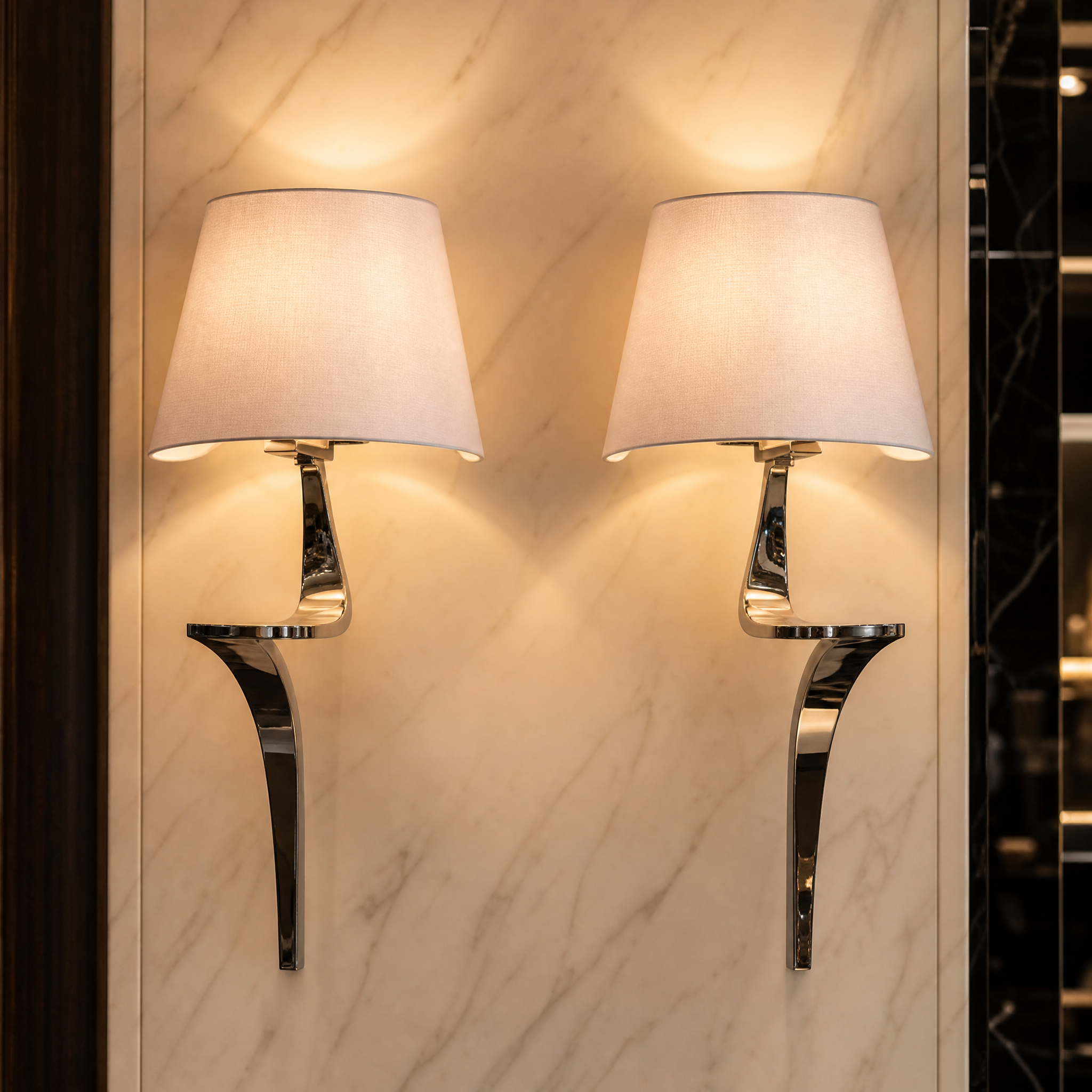 Close-up shot of the Elvoro wall light highlighting the reflective polished nickel finish and the fine texture of the soft cream fabric shade.