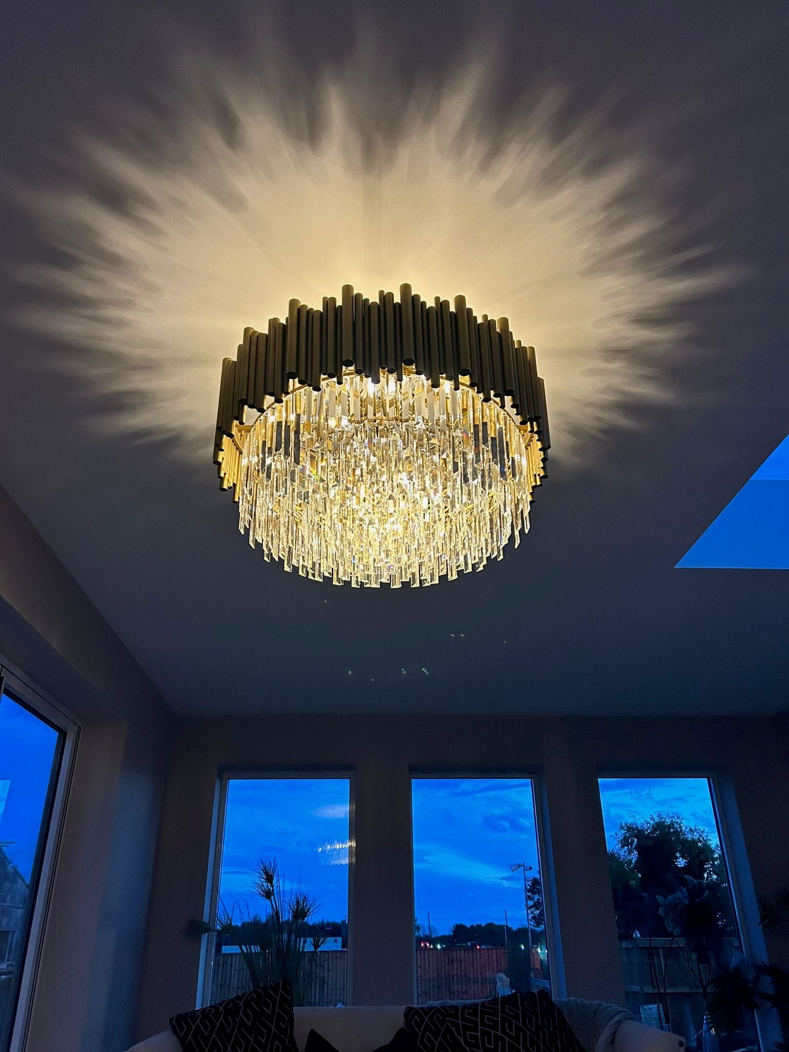 Gotham circular chandelier creating a dramatic halo ceiling light effect