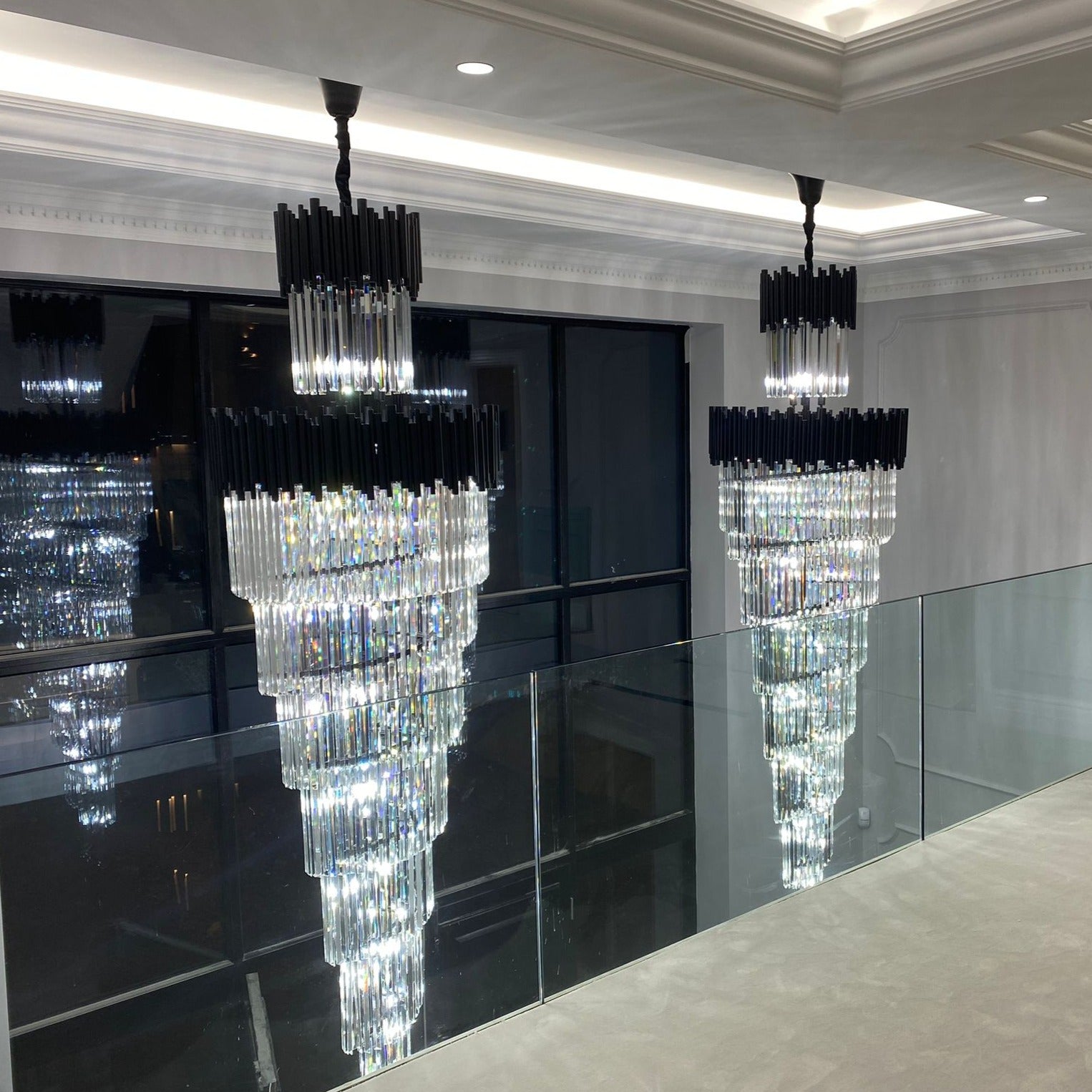 Luxury staircase chandelier with cascading crystal prisms in modern interior