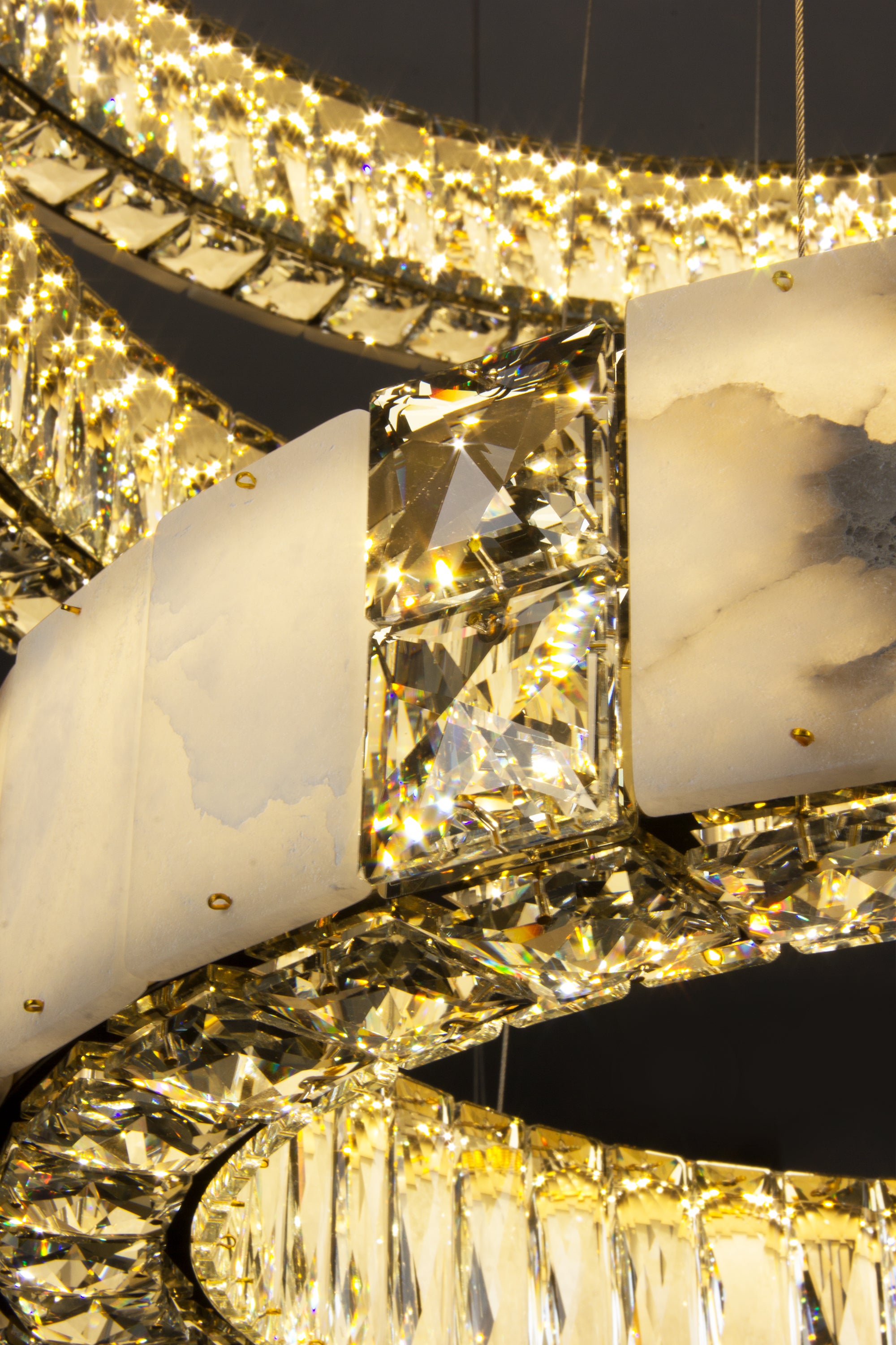 Faceted crystal detailing integrated within the marble ring structure of the Helios Marble Trio Circular Chandelier