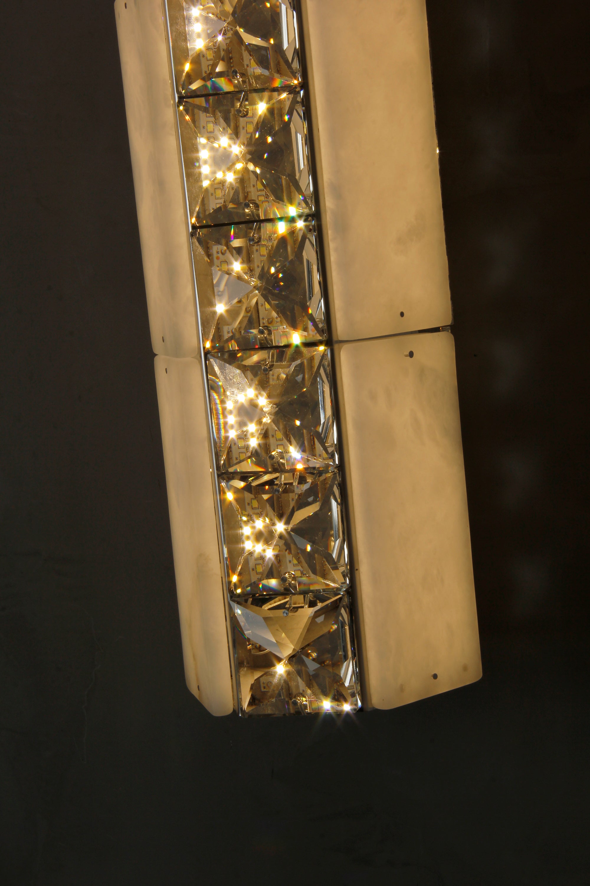 Close-up of natural marble and faceted crystal detailing on the Helios Marble Wall Light