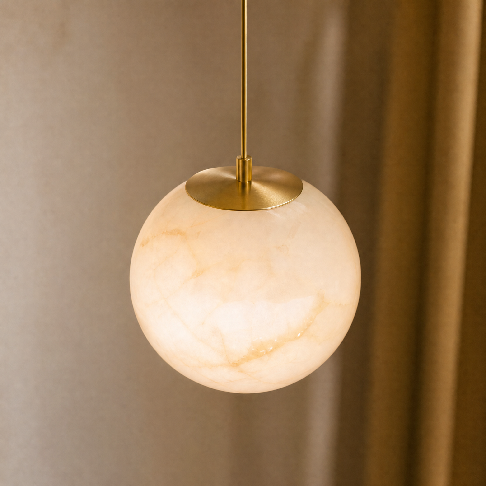 Close-up of the VORELLI Jupiter pendant light showing the intricate natural veining and luminous texture of the hand-carved alabaster globe.