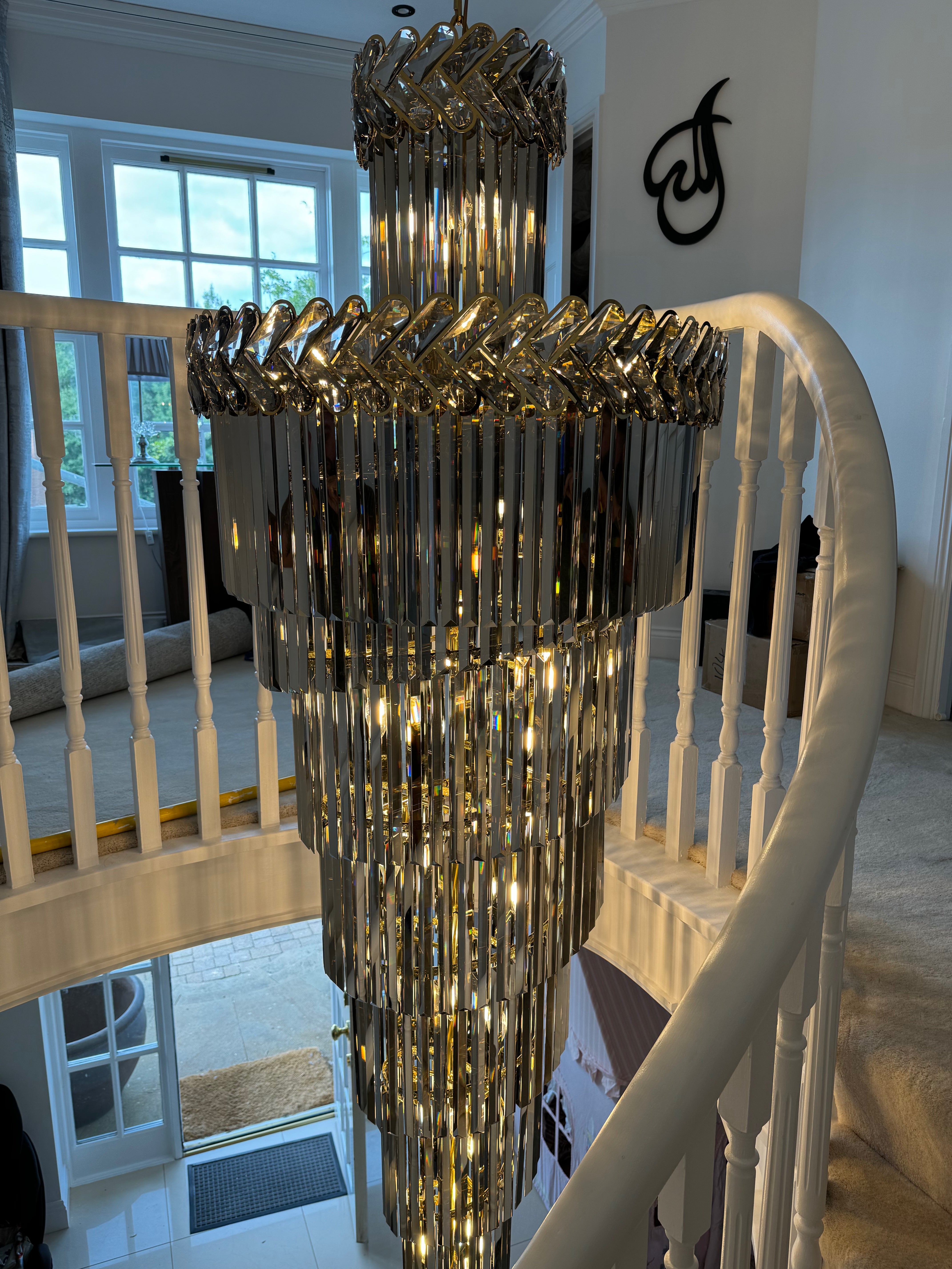 Knightsbridge spiral staircase chandelier installed in a luxury double-height hallway with cascading crystal tiers