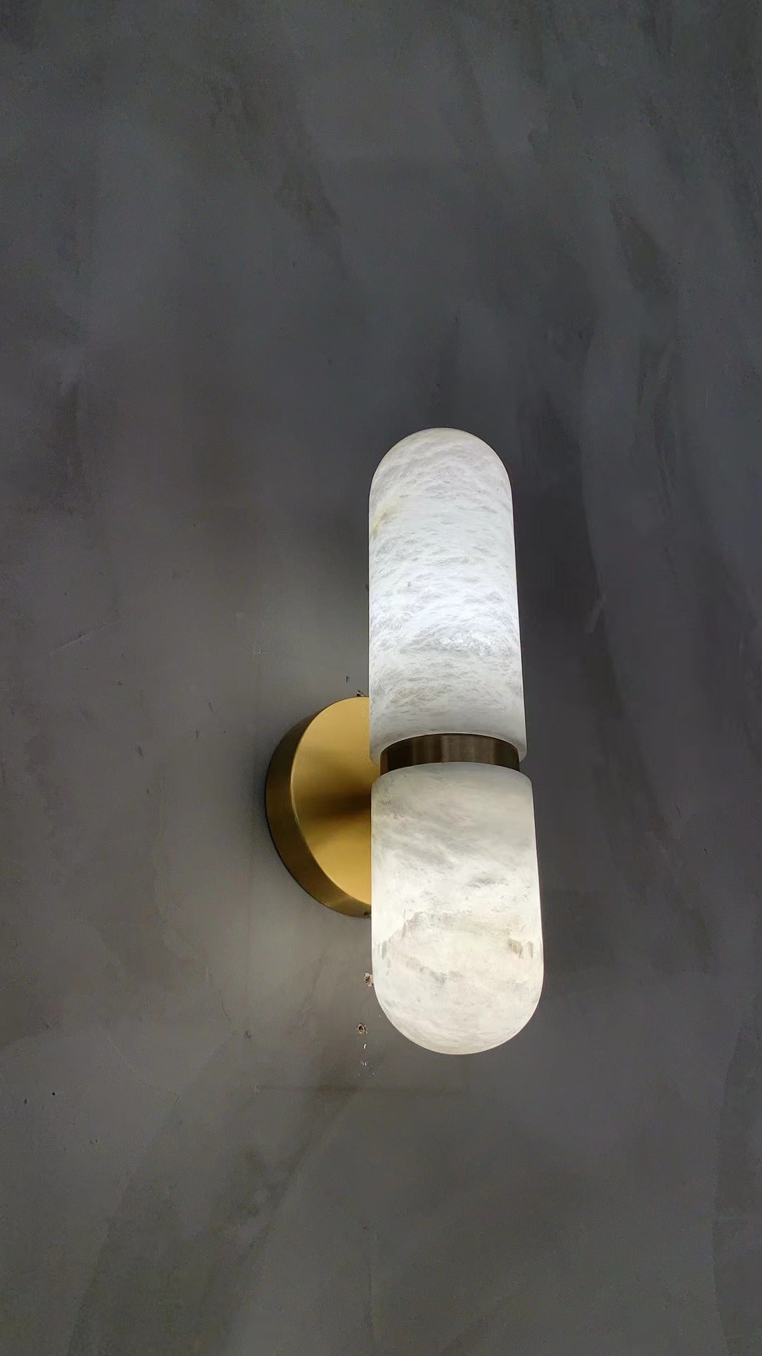 Soft illuminated marble surface of the Luma wall light creating warm ambient lighting