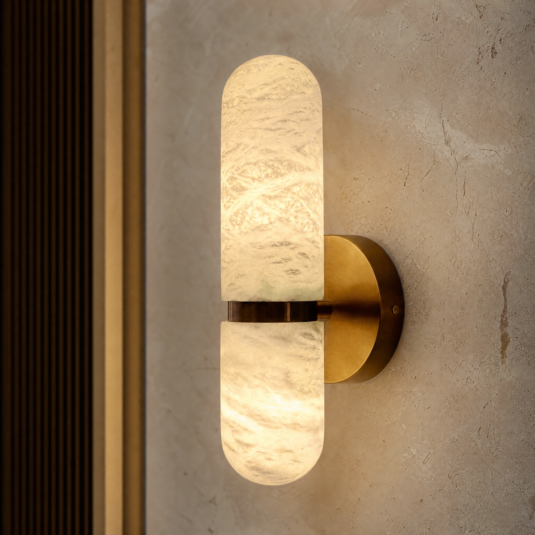 Close-up detail of the VORELLI Luma wall light highlighting the unique natural veining of the sculpted marble shade and refined brass base.