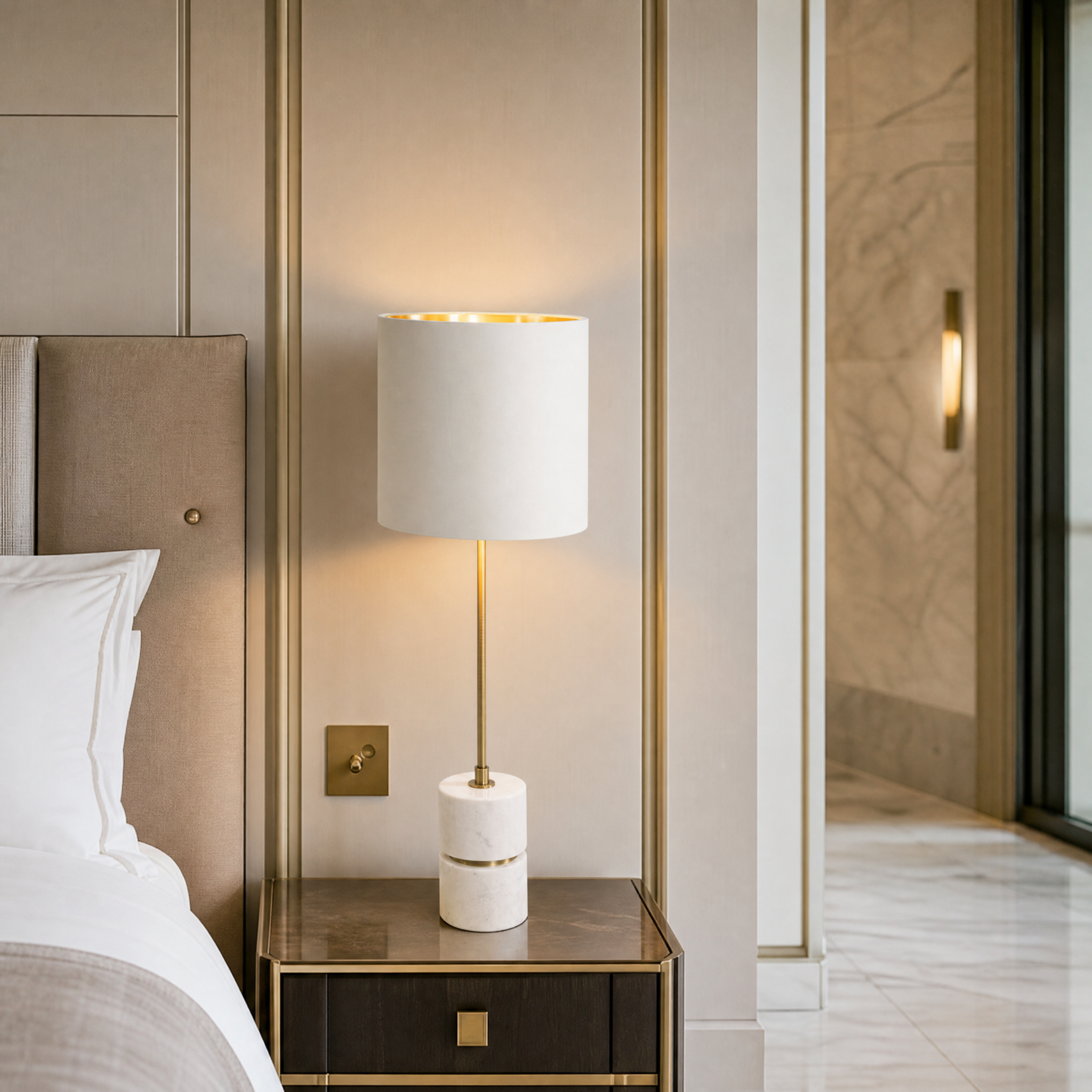 Sophisticated Aurevia brass stem lamp placed on a luxury hotel nightstand with warm ambient glow