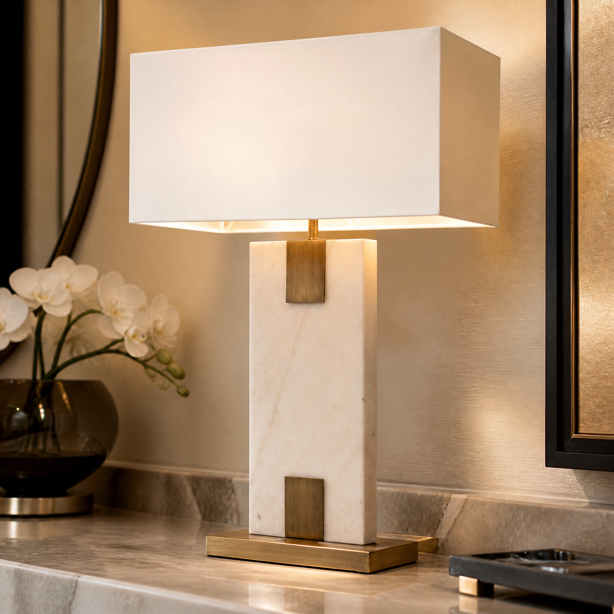Detailed closeup of the Navaro table lamp showcasing the seamless blend of smooth white marble and refined antique brass architectural detailing.