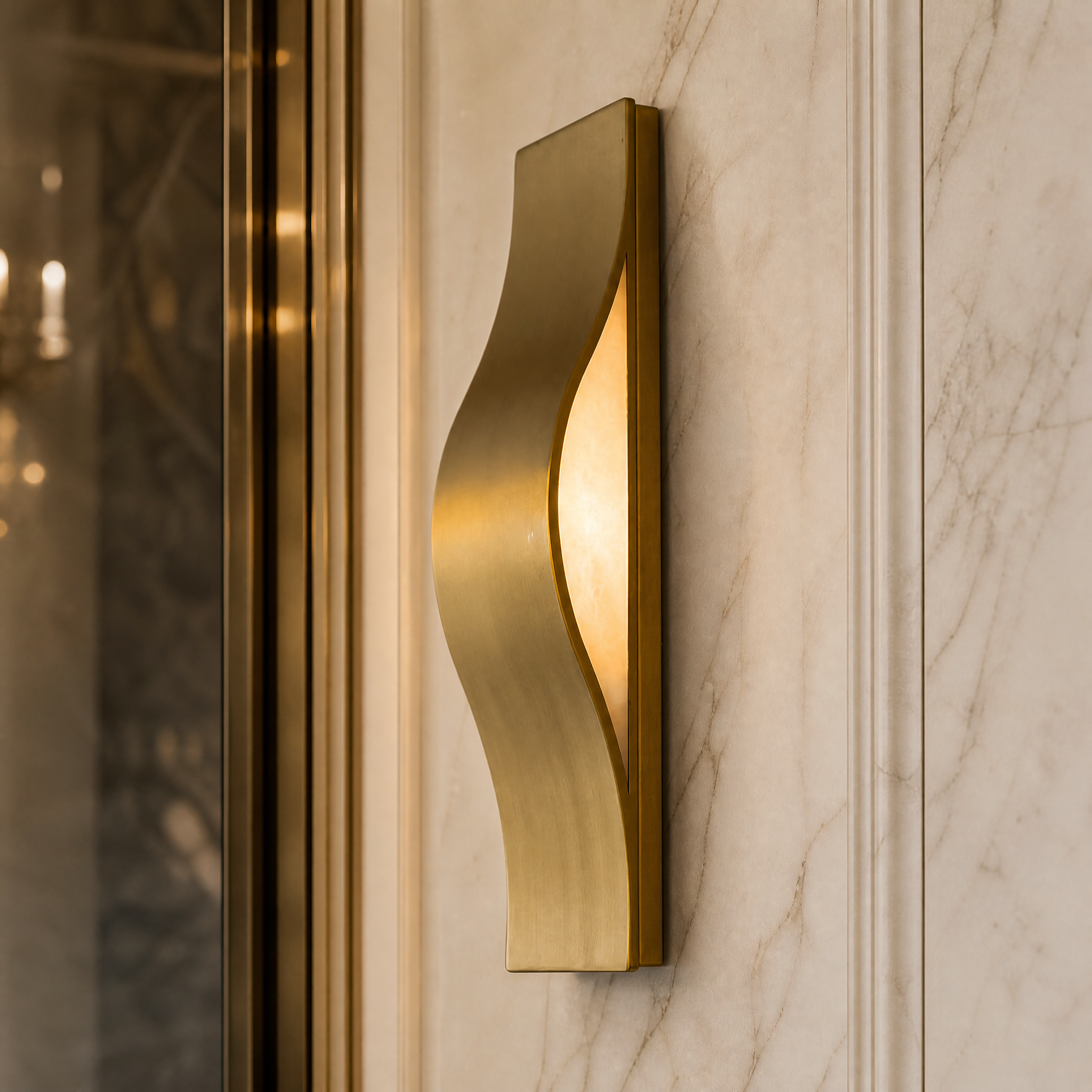 Macro closeup detailing the refined gold finish and inner hidden light source of the fluid, wave-shaped Ondina wall light.