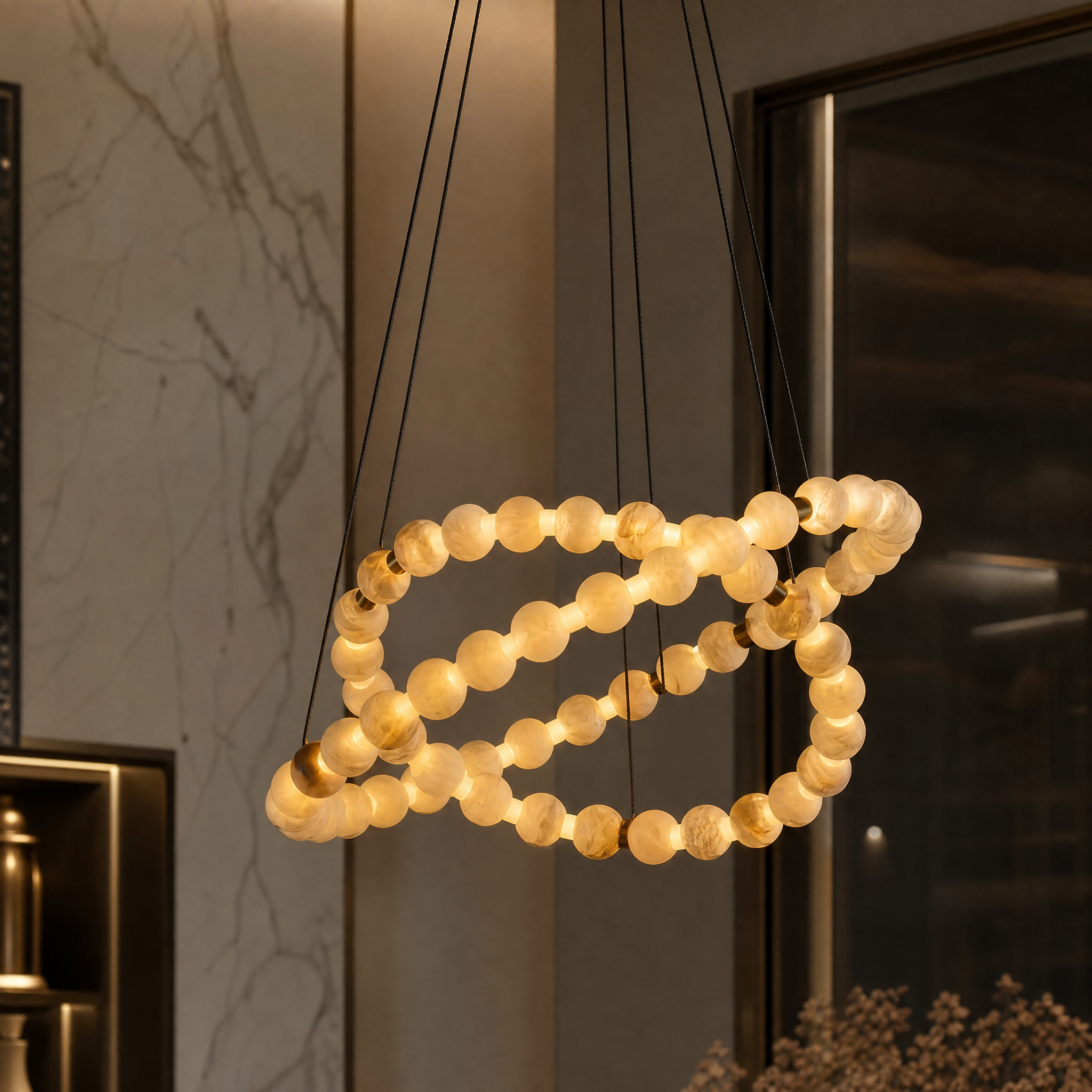 Detailed close-up of the VORELLI Orbella chandelier showing the interlaced rings and textured marble spheres.