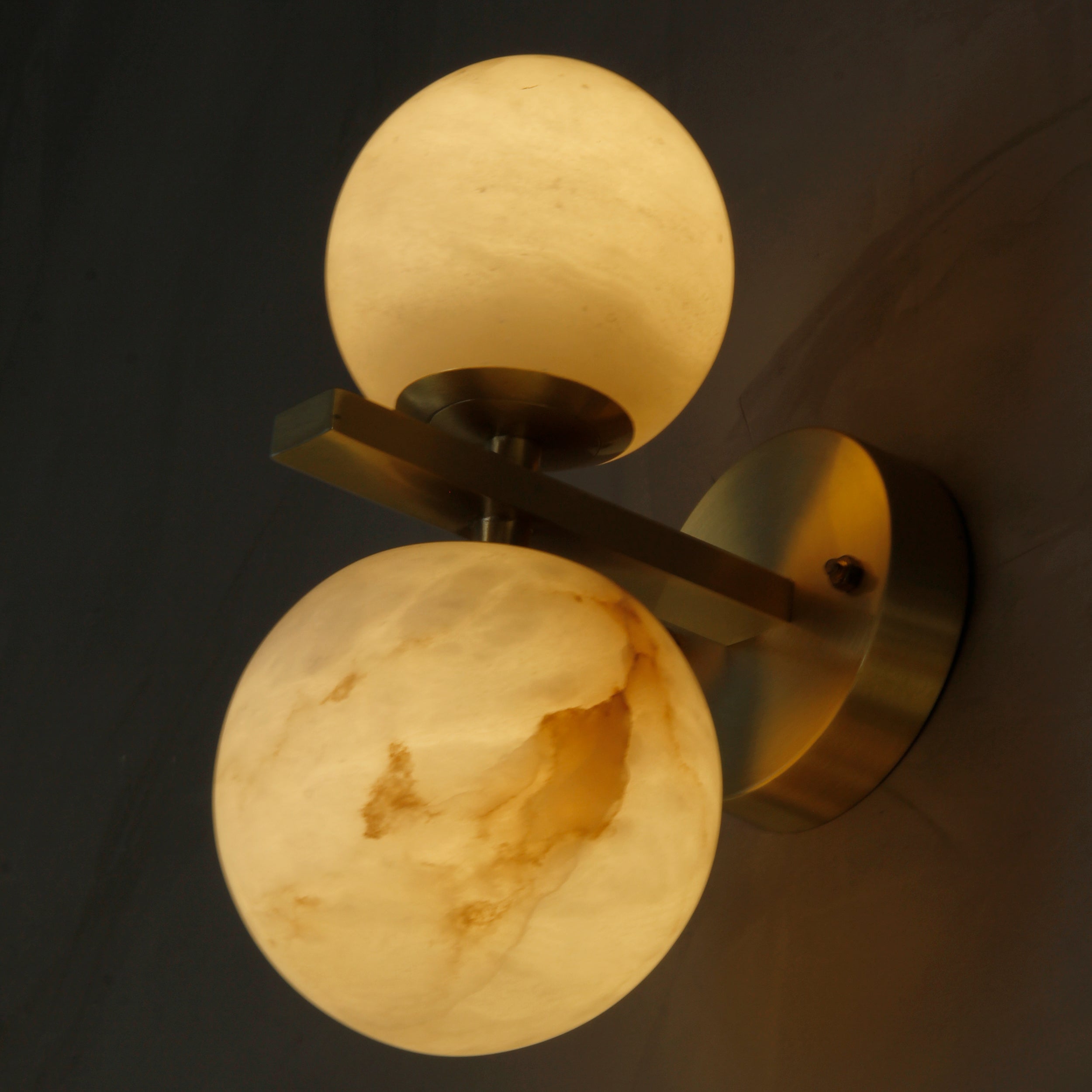 Close up of alabaster globe lights on Ricco marble wall light highlighting natural stone texture