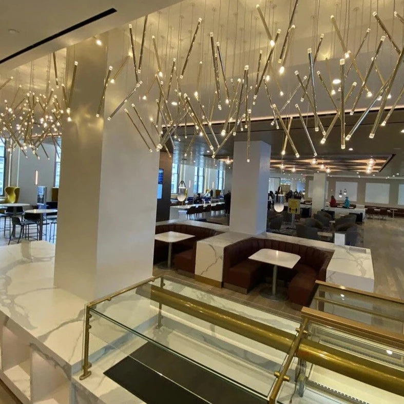 Rizzano linear bar chandelier suspended above dining space in refined modern interior