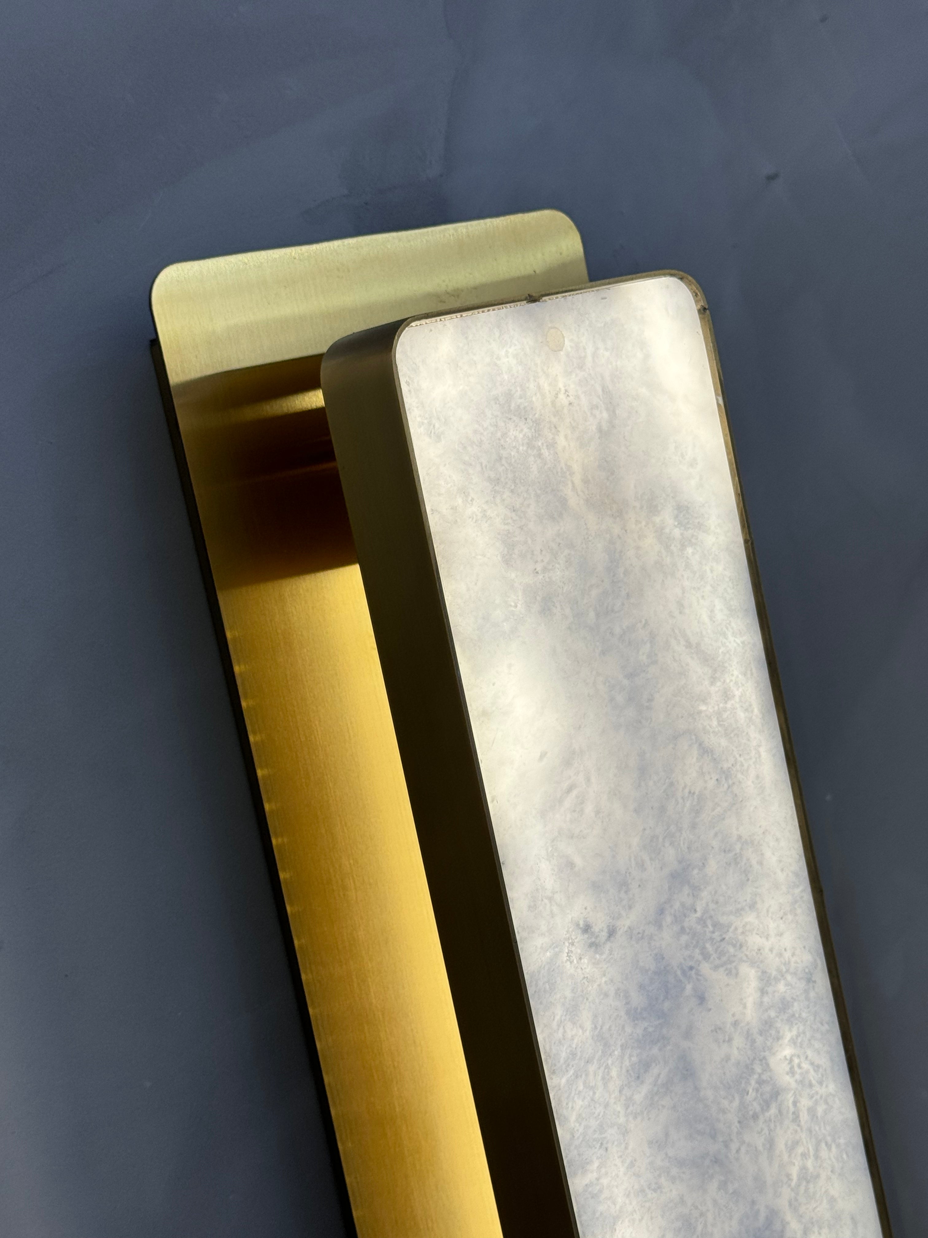Close up angled view of smooth marble surface and structured base on Salerno wall light