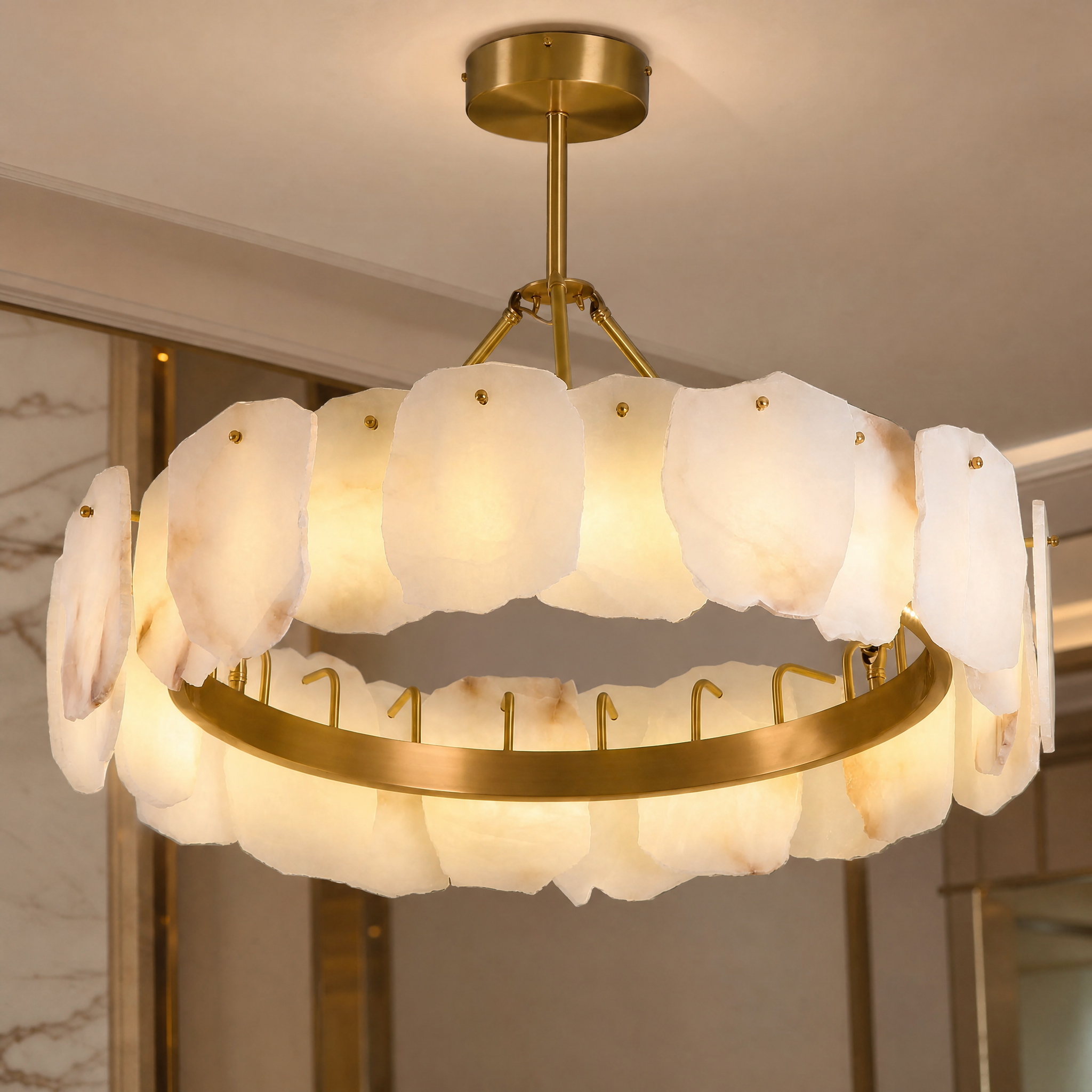 Macro closeup of the VORELLI Silvio Marble Circular Chandelier II, showcasing the unique natural stone textures and precise hand-carved panels against the golden frame.