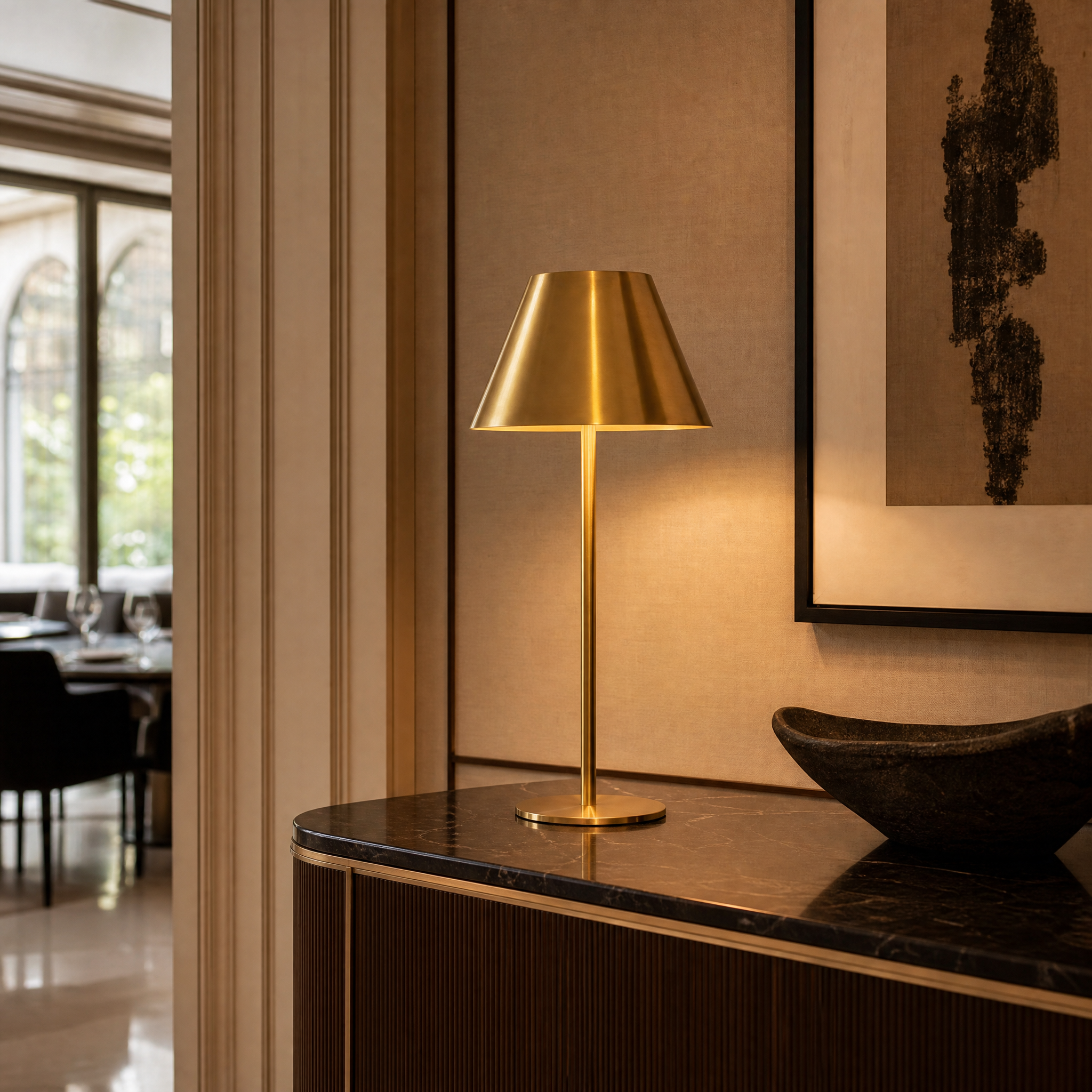 A luxurious hotel bedside setup featuring the VORELLI Solvane tall antique brass table lamp casting warm ambient illumination.
