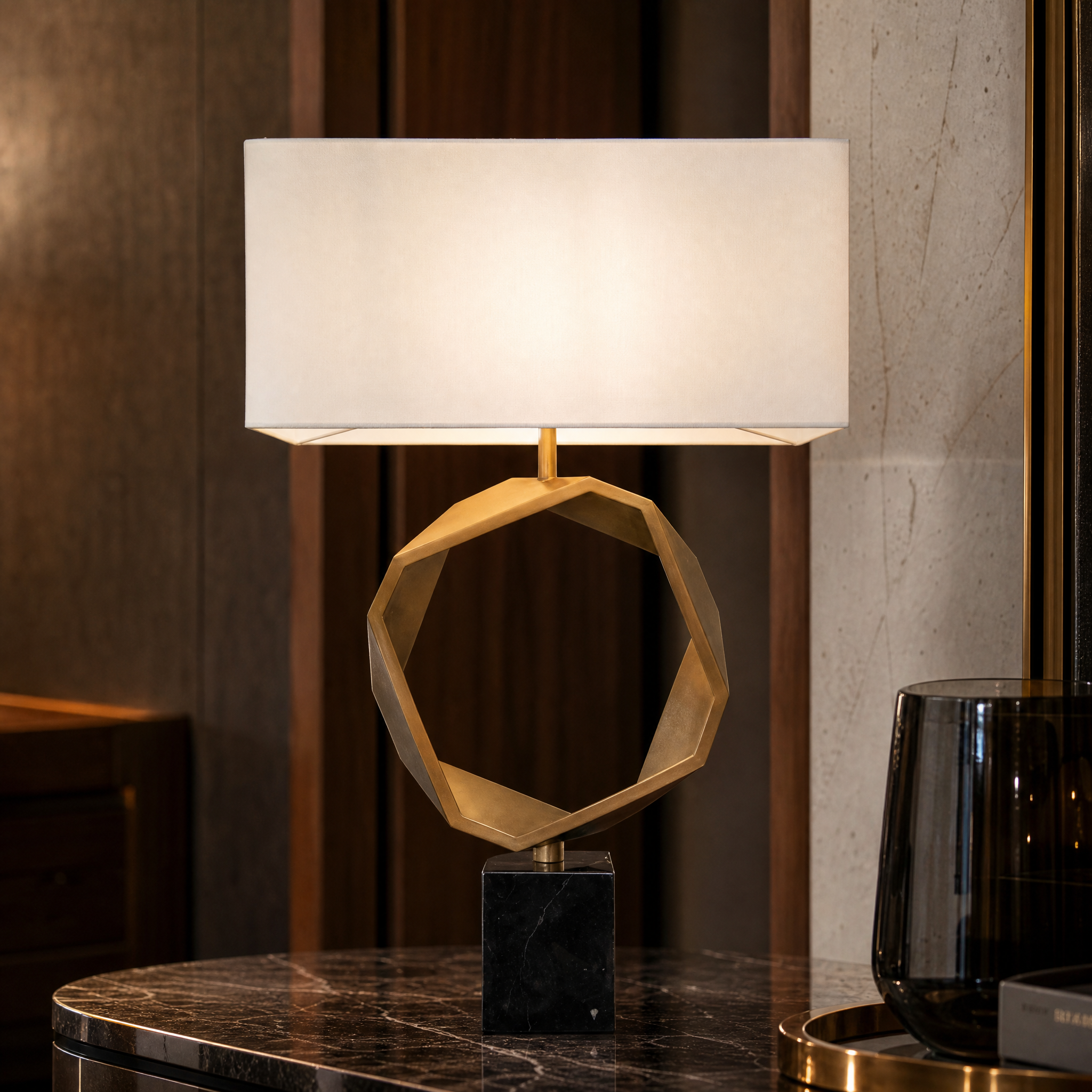 A macro closeup showing the sculptural geometric brass ring, premium fabric shade texture, and bold black marble base of the VORELLI Torvello table lamp.