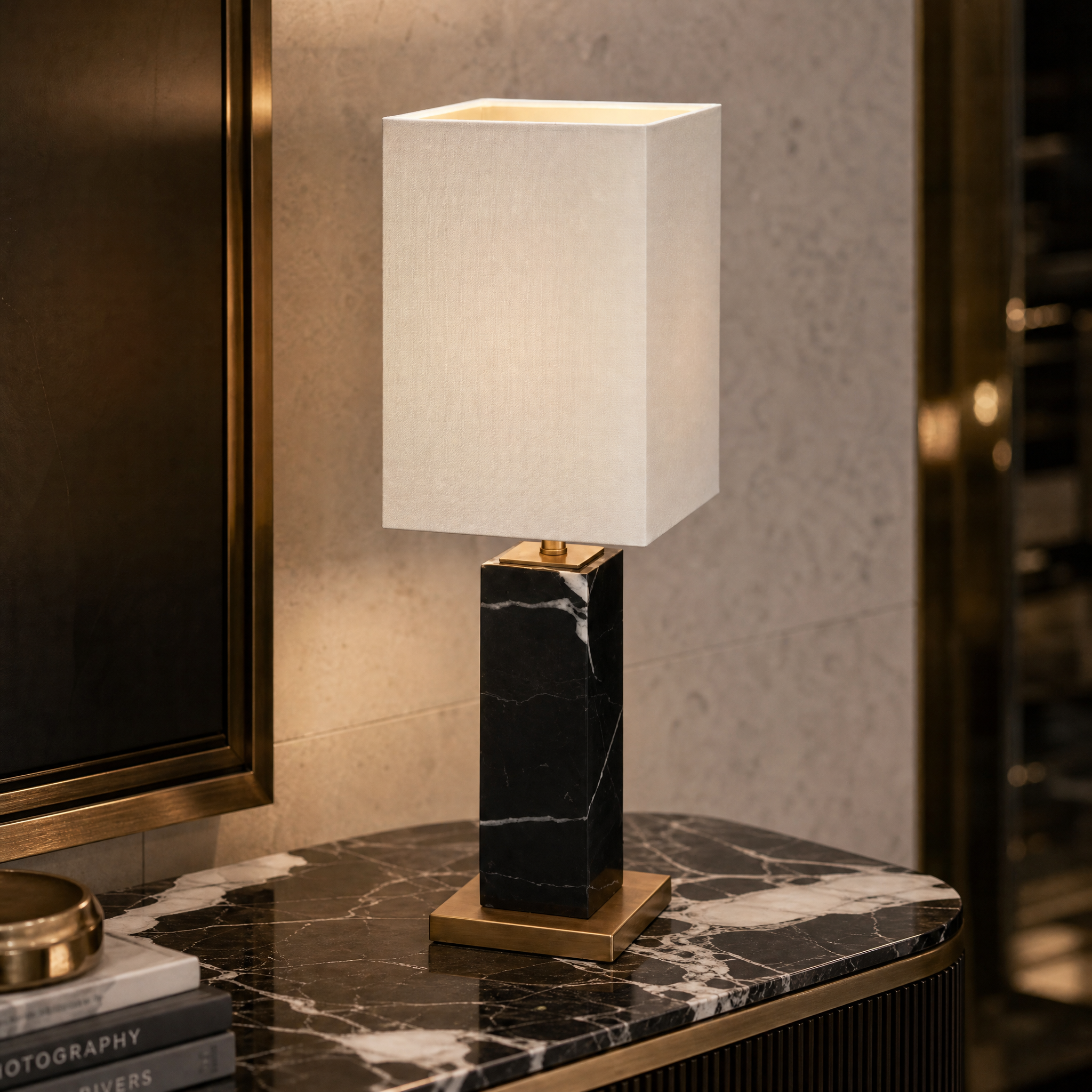 A detailed close-up shot of the Valdoro table lamp highlighting the architectural silhouette of the black marble base and refined antique brass accents.