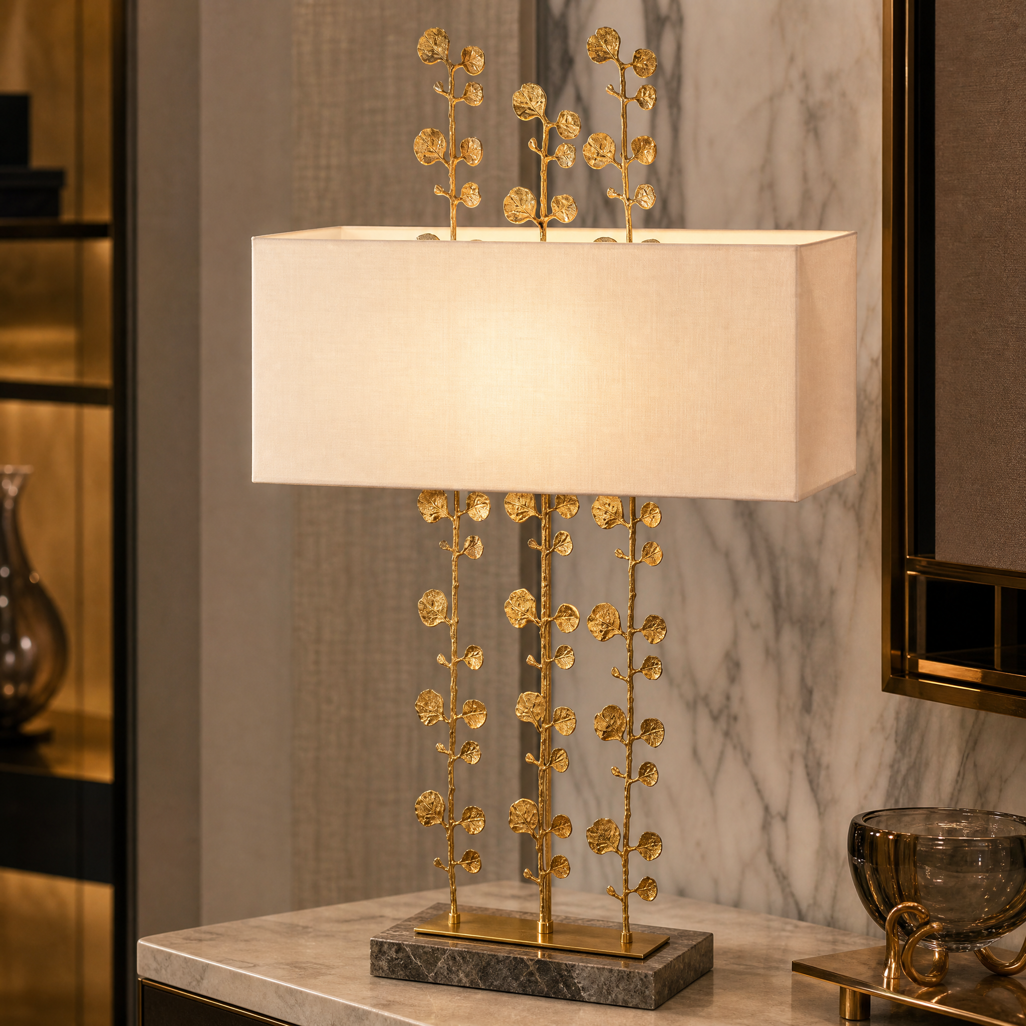 Close-up view of the VORELLI Valenza lamp showcasing the botanical-inspired sculptural brass stems and refined grey marble base.