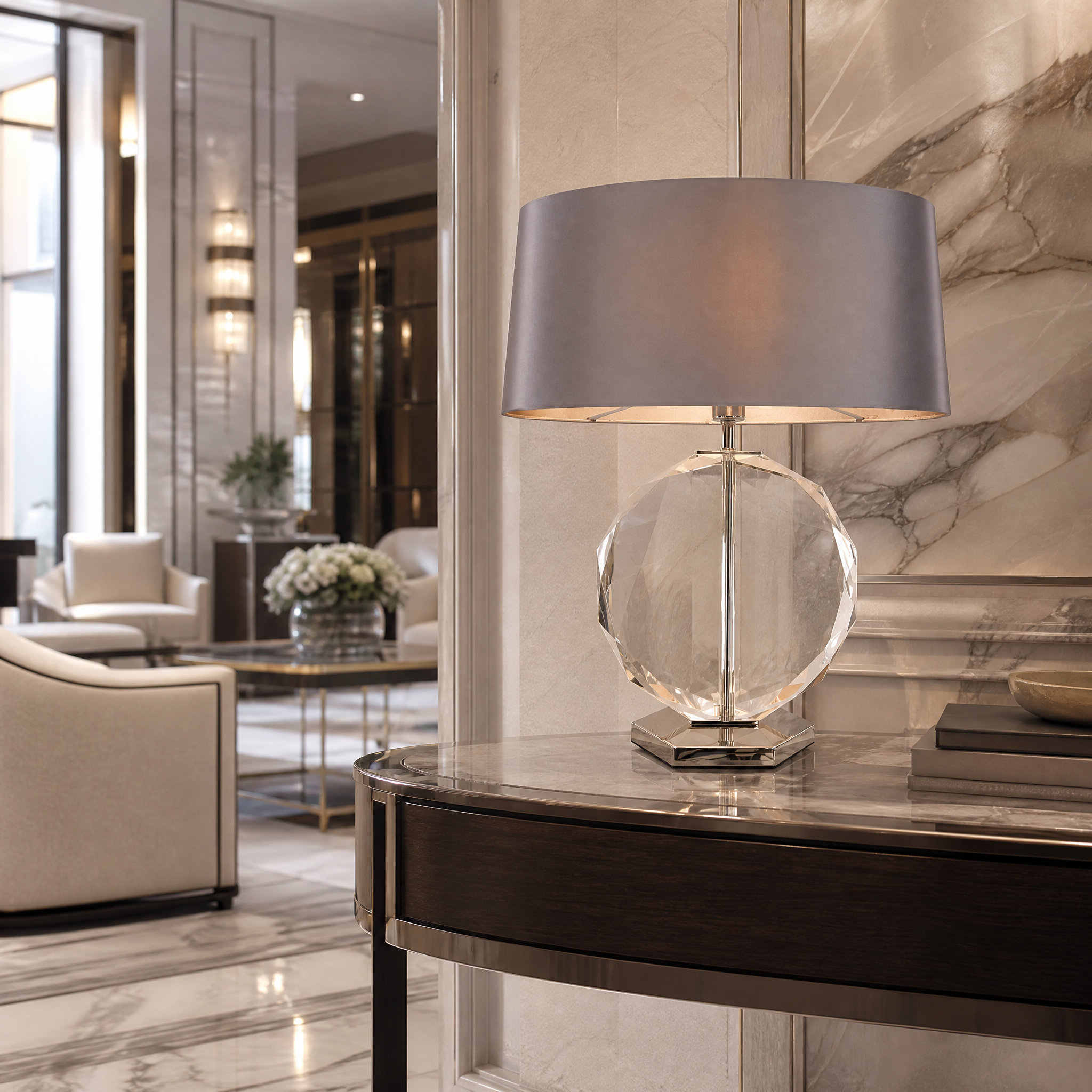 The VORELLI Valmira crystal table lamp casting a soft ambient glow on a console table in a sophisticated luxury hotel lobby interior.