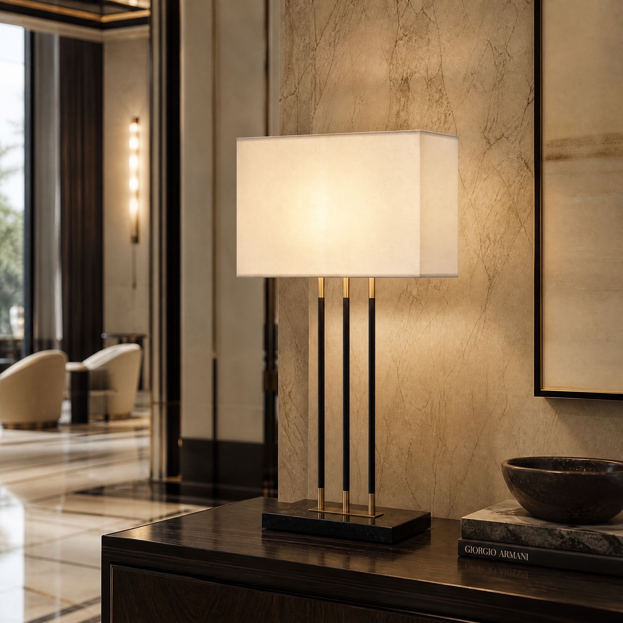 The Varelle brass table lamp with a solid marble base providing sophisticated ambient lighting on a console table in a luxury hospitality or hotel lobby environment.