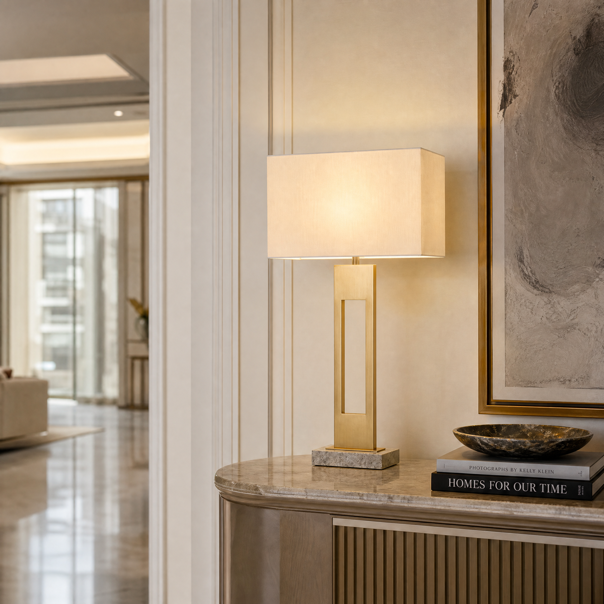 The Varello Brass Table Lamp by VORELLI styled in a modern residential living room, showcasing its clean geometric lines and warm ambient glow.