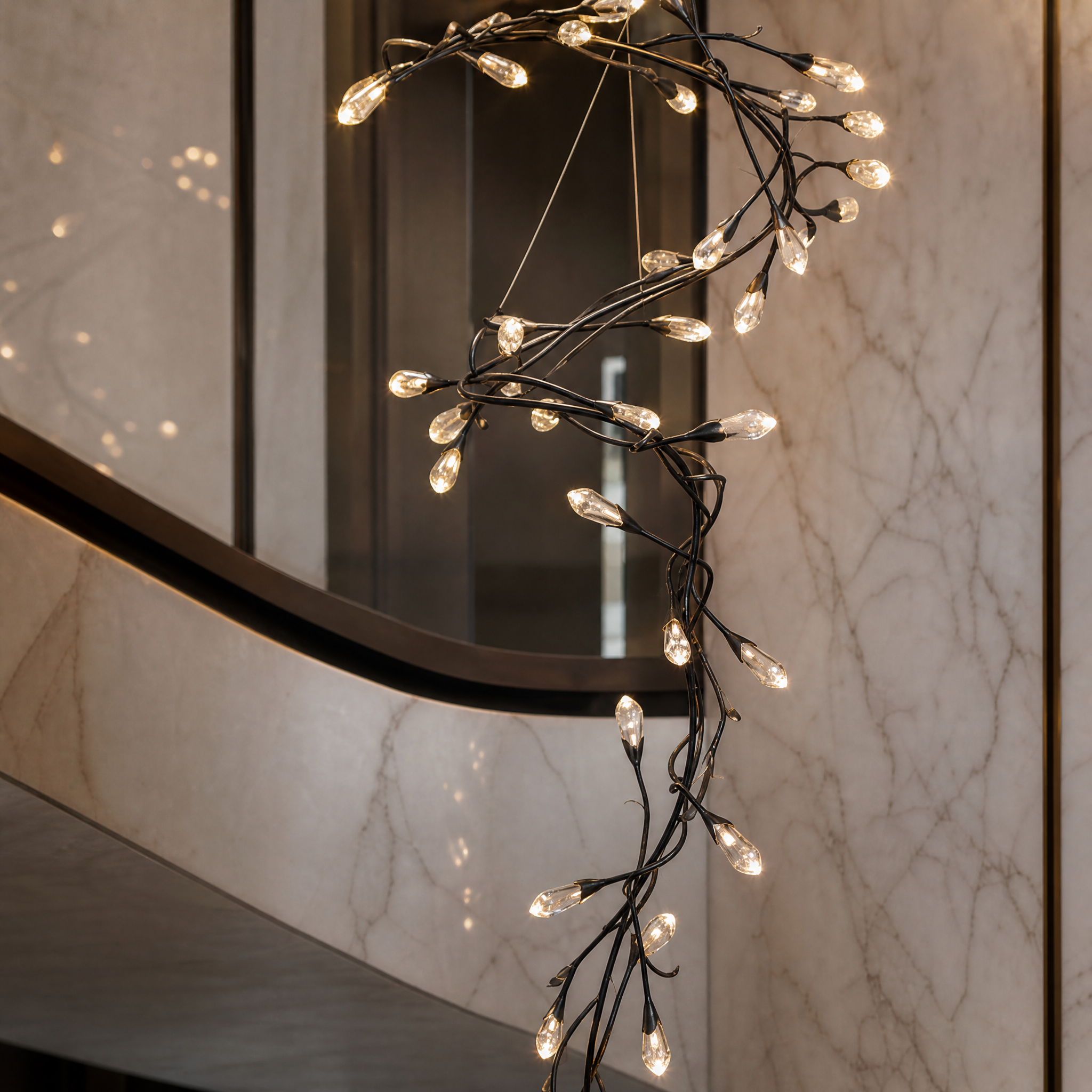 A detailed close-up shot of the delicate crystal drops on the Virella linear staircase chandelier, highlighting the flowing vertical composition.
