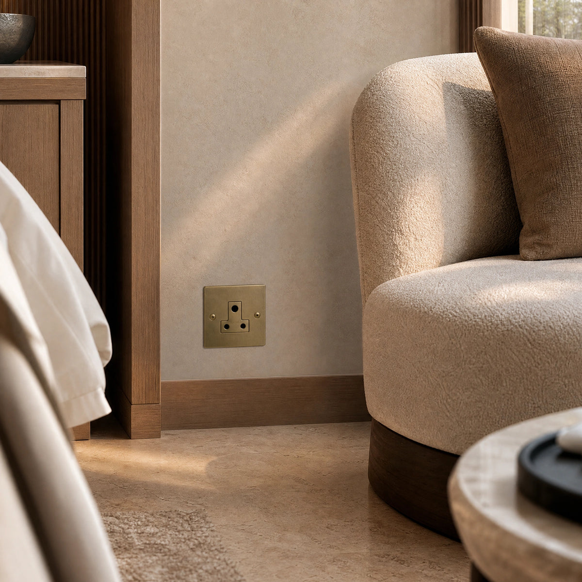 Luxury antique brass 5a socket installed within bespoke bedside joinery or low-level wall beside a luxury seating area in a UHNW interior by VORELLI®.