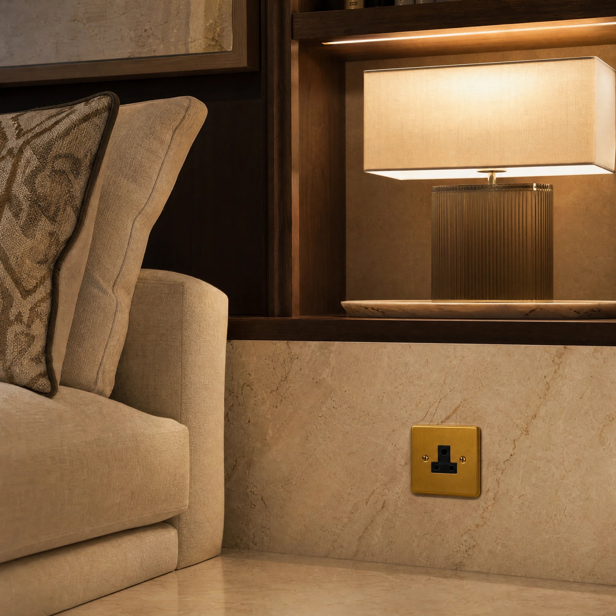 Luxury antique brass 5a socket installed within bespoke bedside joinery or low-level wall beside a luxury seating area in a UHNW interior by VORELLI®.