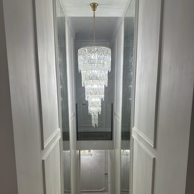 VORELLI® Abruzzi spiral crystal staircase chandelier installed in a luxury double-height stairwell with cascading diamond cut faceted crystals