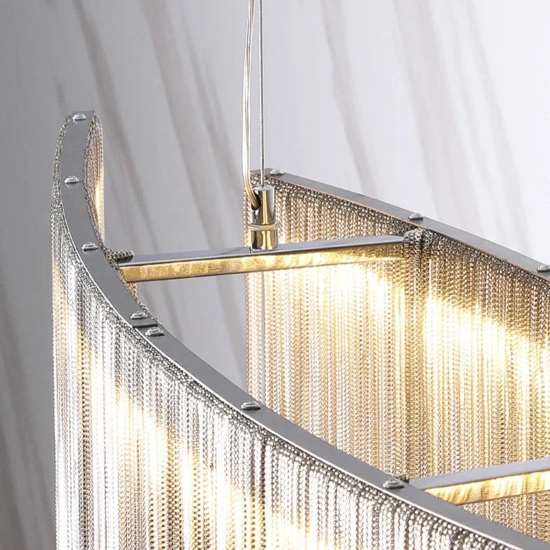 VORELLI® Adlington Arc Chandelier with golden light reflecting through curved chain strands
