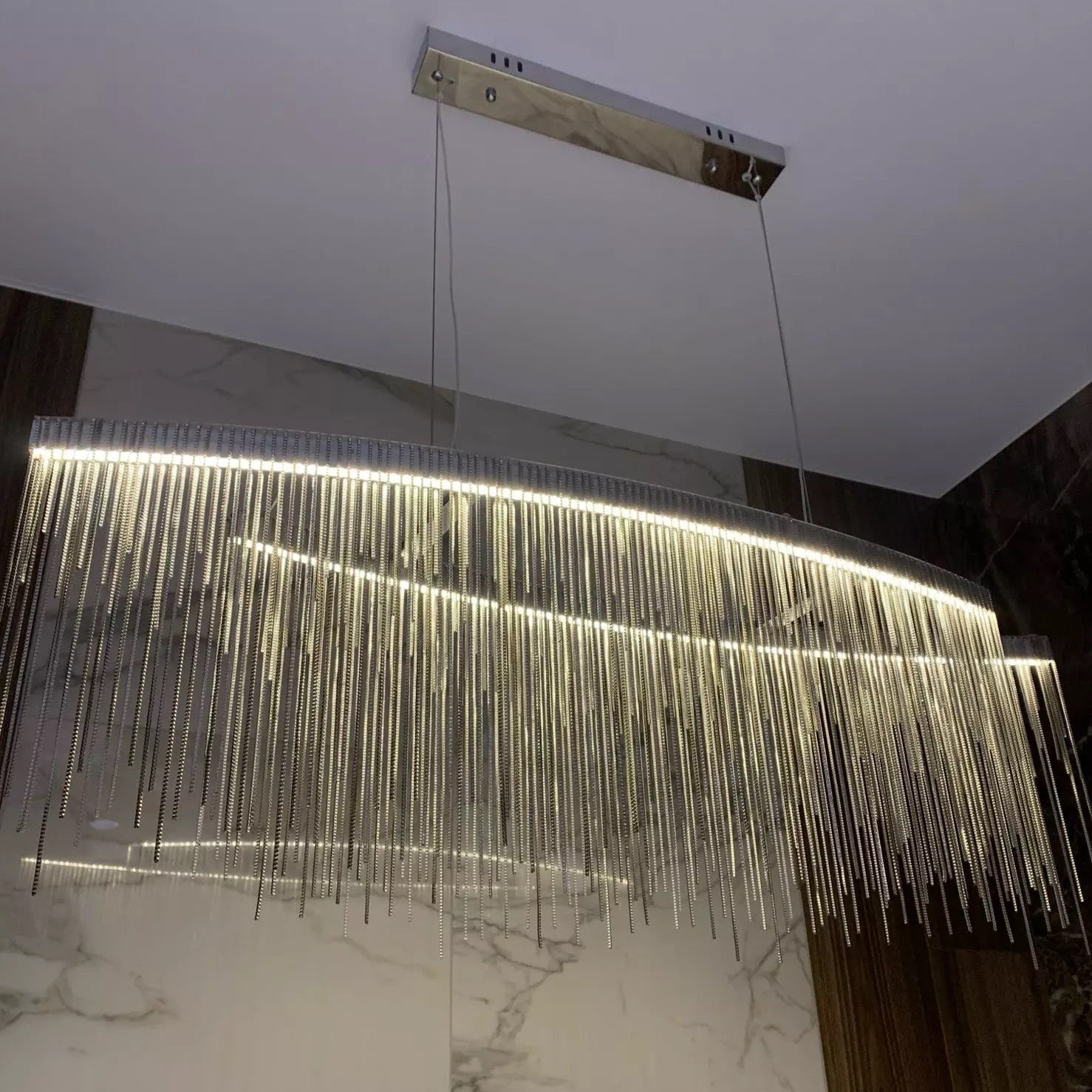 Close-up of VORELLI® Adlington Arc Chandelier’s layered chain design in a moody interior