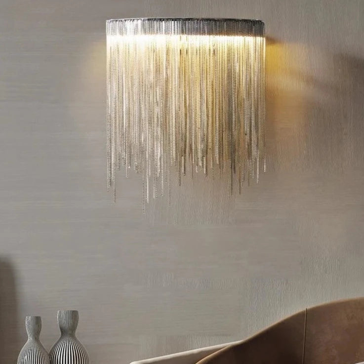 VORELLI® Adlington Wall Light with cascading gold chains glowing against a soft beige wall