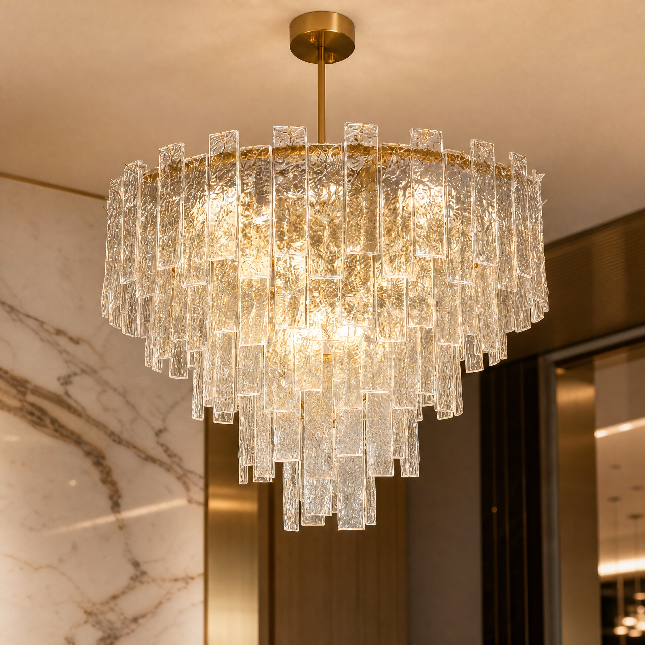 A detailed closeup of the VORELLI Ambani Chandelier, highlighting the unique texture of cascading cracked crystal pieces capturing and refracting radiant light.
