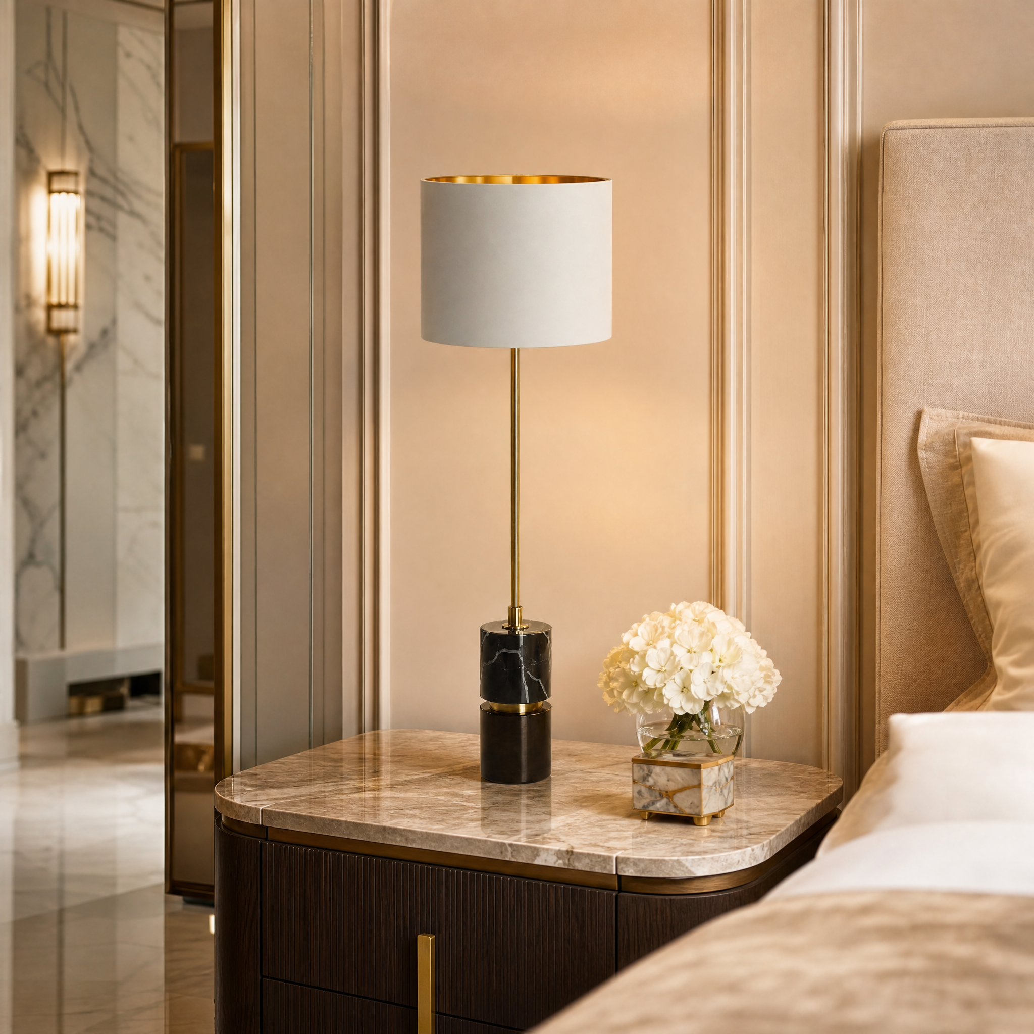 VORELLI Aurevia slim black marble table lamp with an antique brass trim and fabric shade illuminating a luxury residential bedroom bedside table.