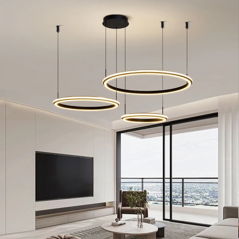 Three suspended LED rings forming the Bellezza trio chandelier in a bright modern interior.