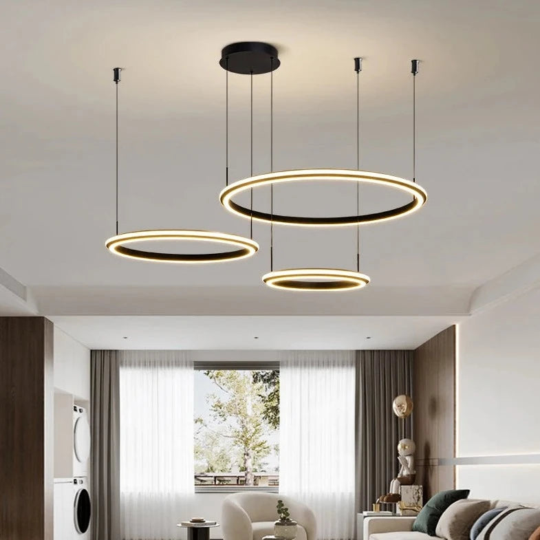 Tri-ring LED chandelier creating a warm, modern ambiance in a contemporary living space.